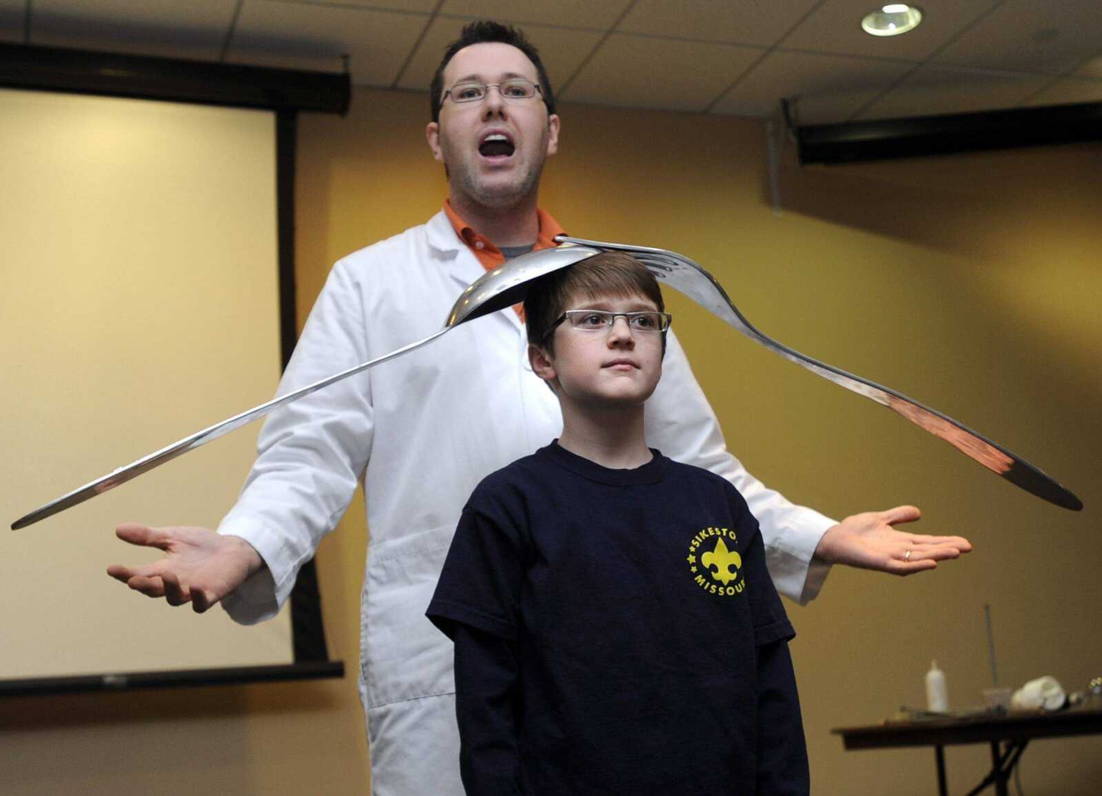 Easton Lovall of Sikeston, Mo., a Webelos scout, assists Jason Lindsey with a science demonstration during STEM University on Saturday at Southeast Missouri State University in Cape Girardeau. (Fred Lynch)