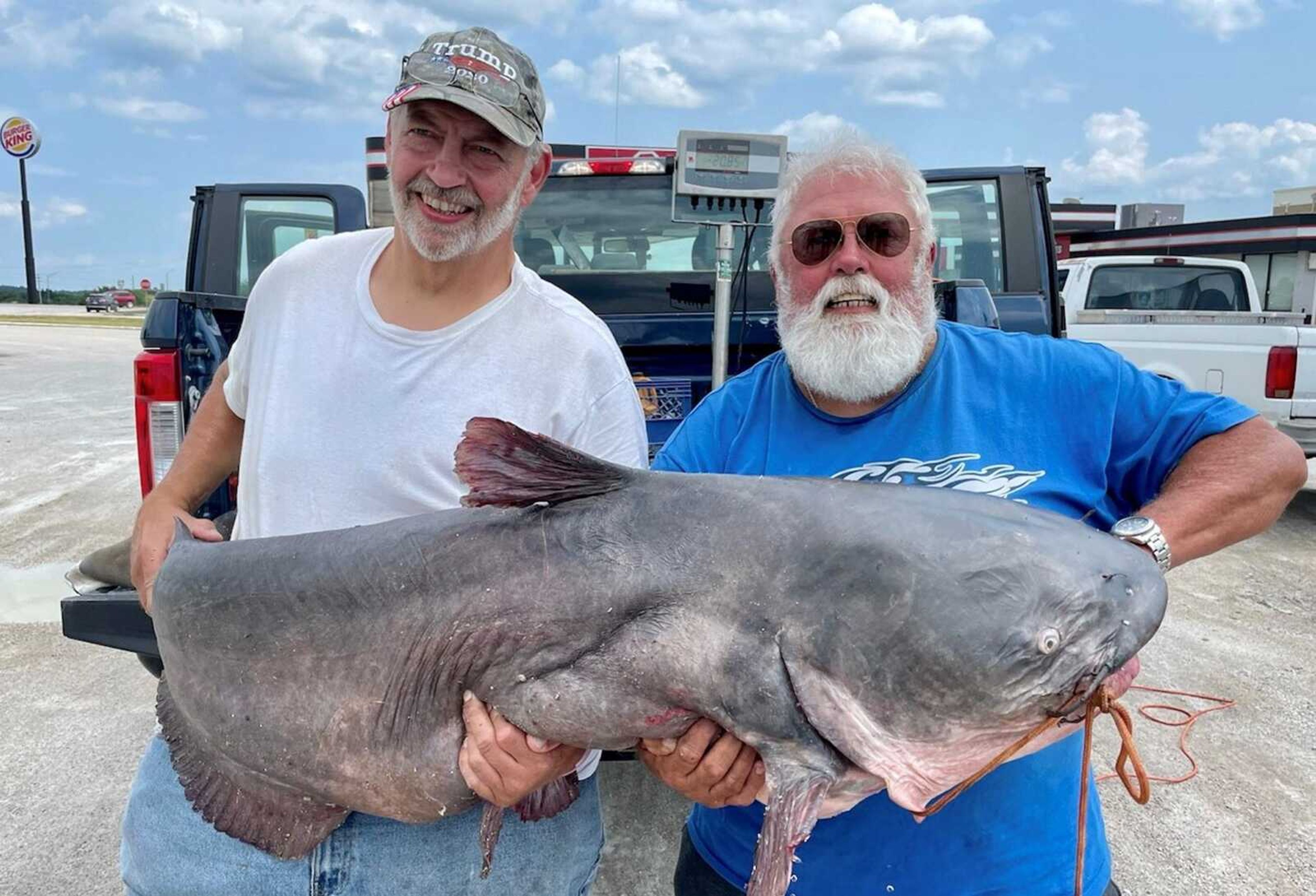 Carey Branham, right, and his brother Greg hold up a 101-pound blue catfish they caught on the Mississippi River.