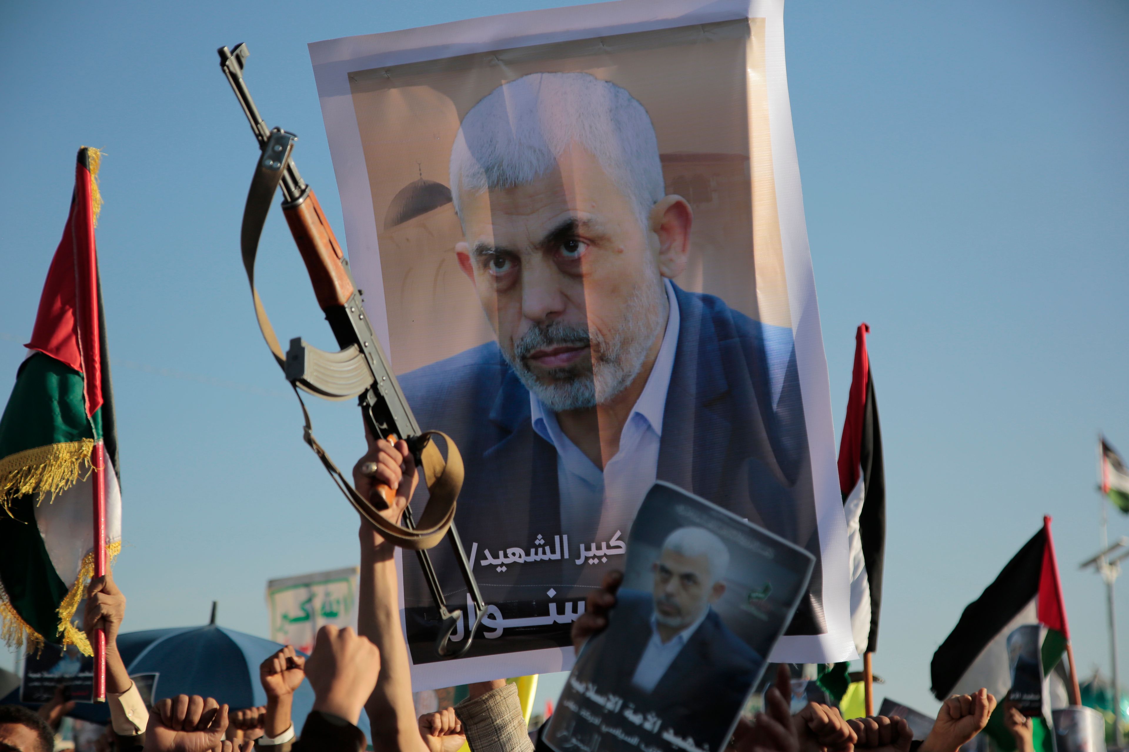 Houthi supporters raise a poster of Hamas leader Yahya Sinwar, who killed by Israeli troops in Gaza, during an anti-Israel rally in Sanaa, Yemen, Friday, Oct. 18, 2024. (AP Photo/Osamah Abdulrahman)