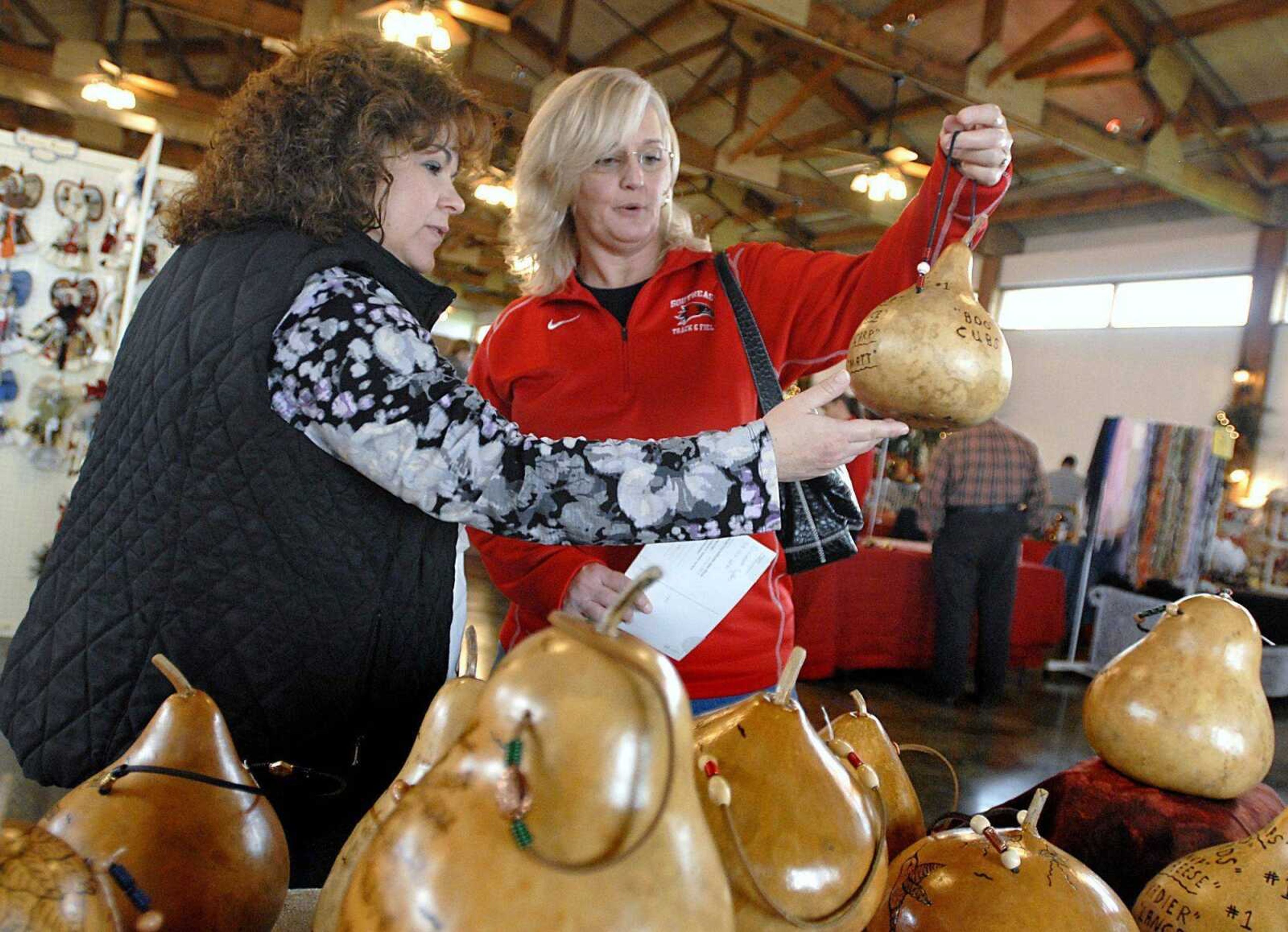 Sarah Wright, left, and Janice Green look at wren bird houses on Saturday hand-crafted from gourds by Robert Lee during the Christmas Extravaganza Crafts, Gifts and Collectibles Show at the Bavarian Halle in Jackson. For more images, visit semissourian.com. (Kristin Eberts)