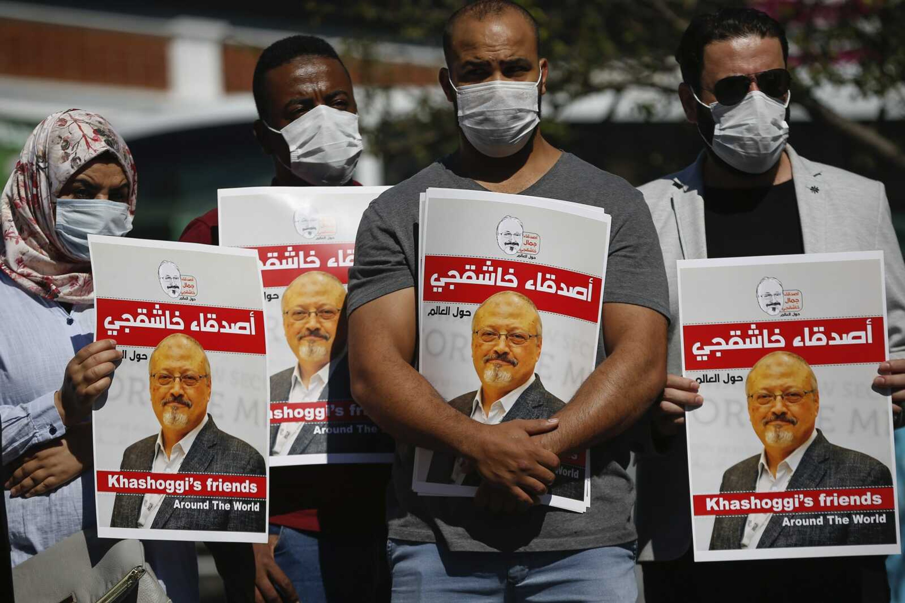 People hold posters of slain Saudi journalist Jamal Khashoggi on Oct. 2, 2020, near the Saudi Arabia consulate in Istanbul, marking the two-year anniversary of his death. A Turkish court ruled Thursday to suspend the trial in absentia of 26 Saudis accused in the killing of Jamal Khashoggi and for the case to be transferred to Saudi Arabia.