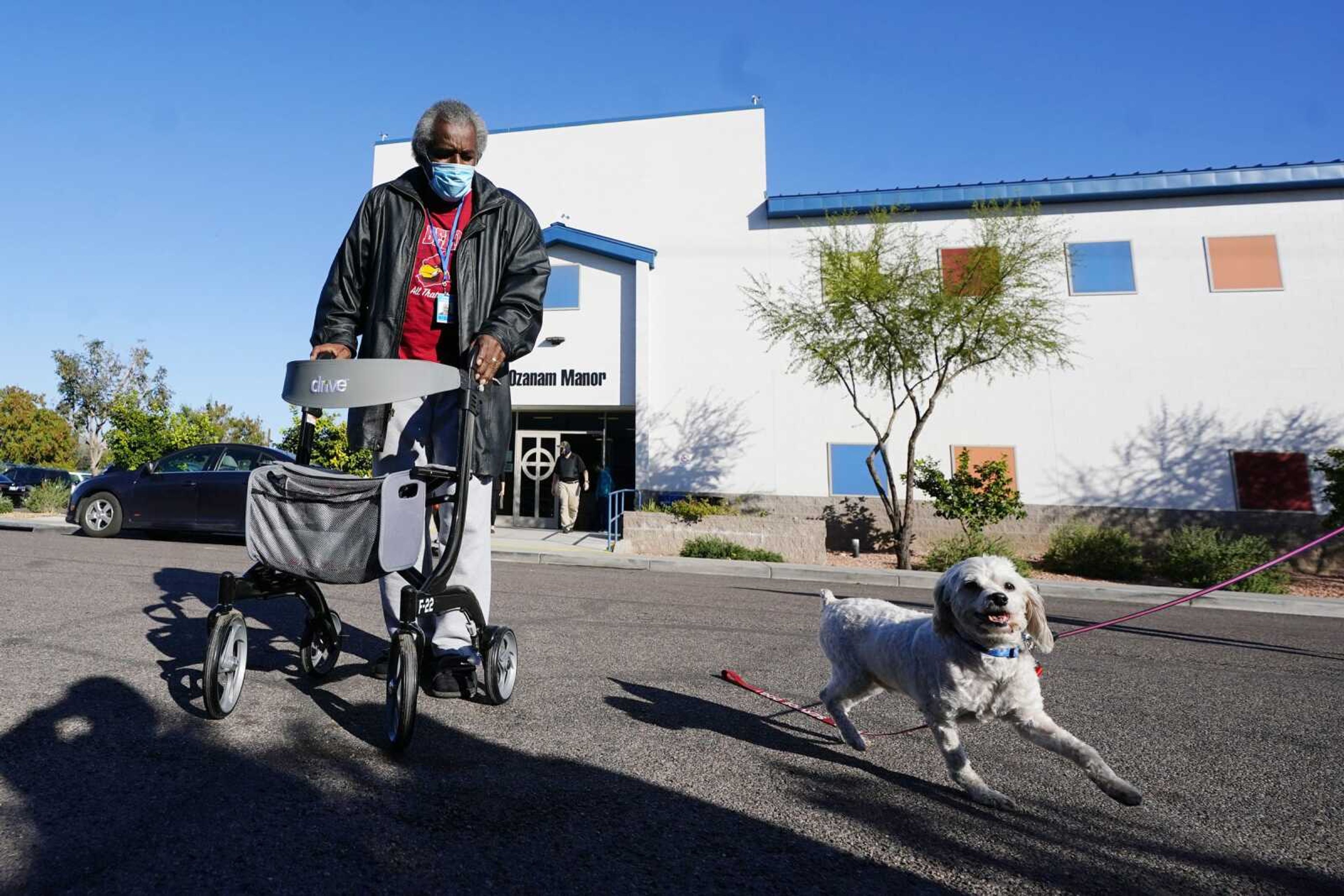 Lovia Primous, 67, walks across the street from Ozanam Manor temporary housing Jan. 24 in Phoenix. A stroke started 67-year-old Army veteran Primous on his downward spiral, costing him his job and forcing him to sleep in his Honda Accord. He was referred to the transitional shelter after recovering from COVID-19.