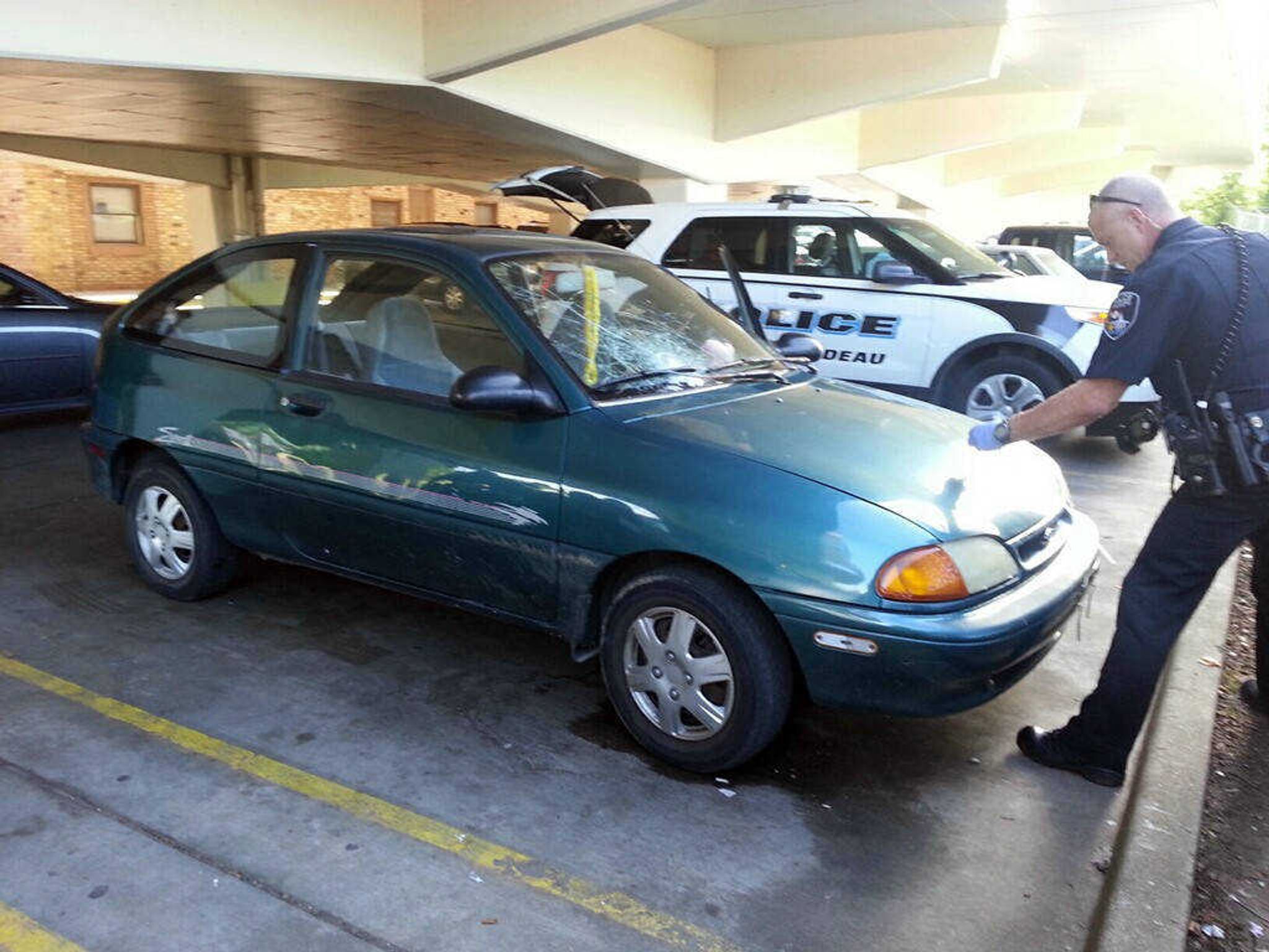 A Cape Girardeau police officer processes evidence at a car at 45 S. West End Blvd. identified as the vehicle that struck a junior-high student Tuesday afternoon. (Laura Simon)