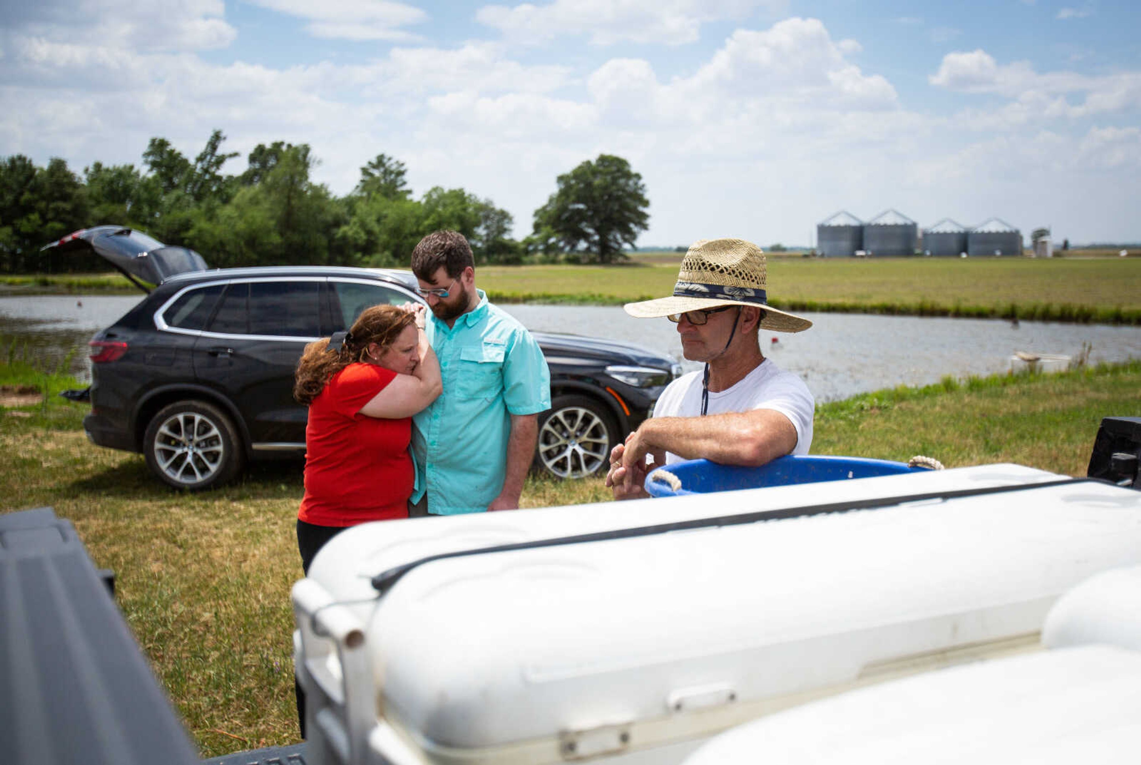 Amy Jo Hunter hangs on the shoulder of her son Benjamin Hunter as her husband Ben Hunter stands at the back of his truck that is loaded with coolers of freshly-caught crawfish at their farm west of Sikeston, Mo. The family turned their hobby of crawfish trapping into a business, opening Semo Crawfish Company last year.