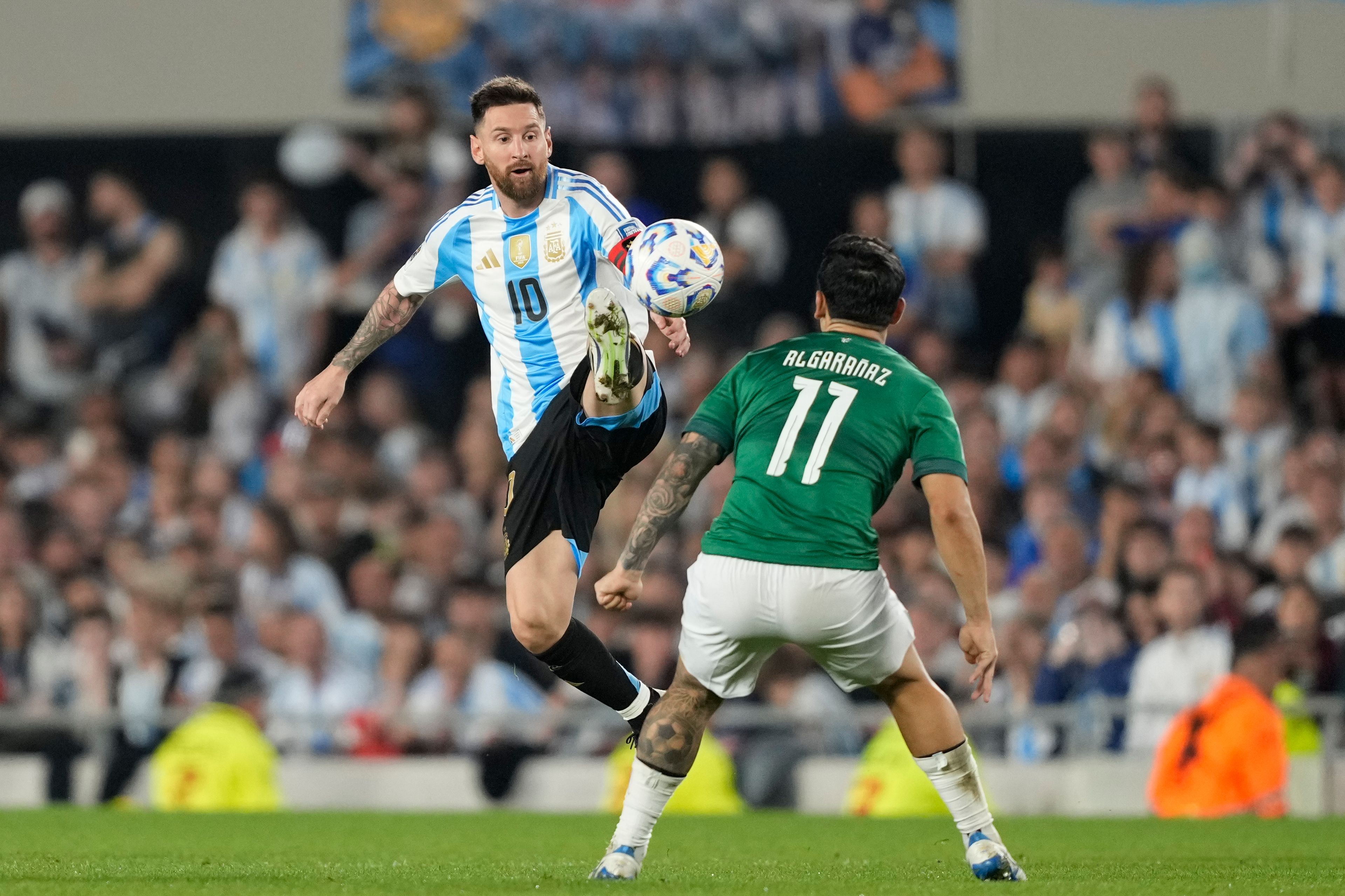 Argentina's Lionel Messi jumps for the ball challenged by Bolivia's Carmelo Algaranaz during a World Cup 2026 qualifying soccer match at Monumental stadium in Buenos Aires, Argentina, Tuesday, Oct. 15, 2024. (AP Photo/Natacha Pisarenko)