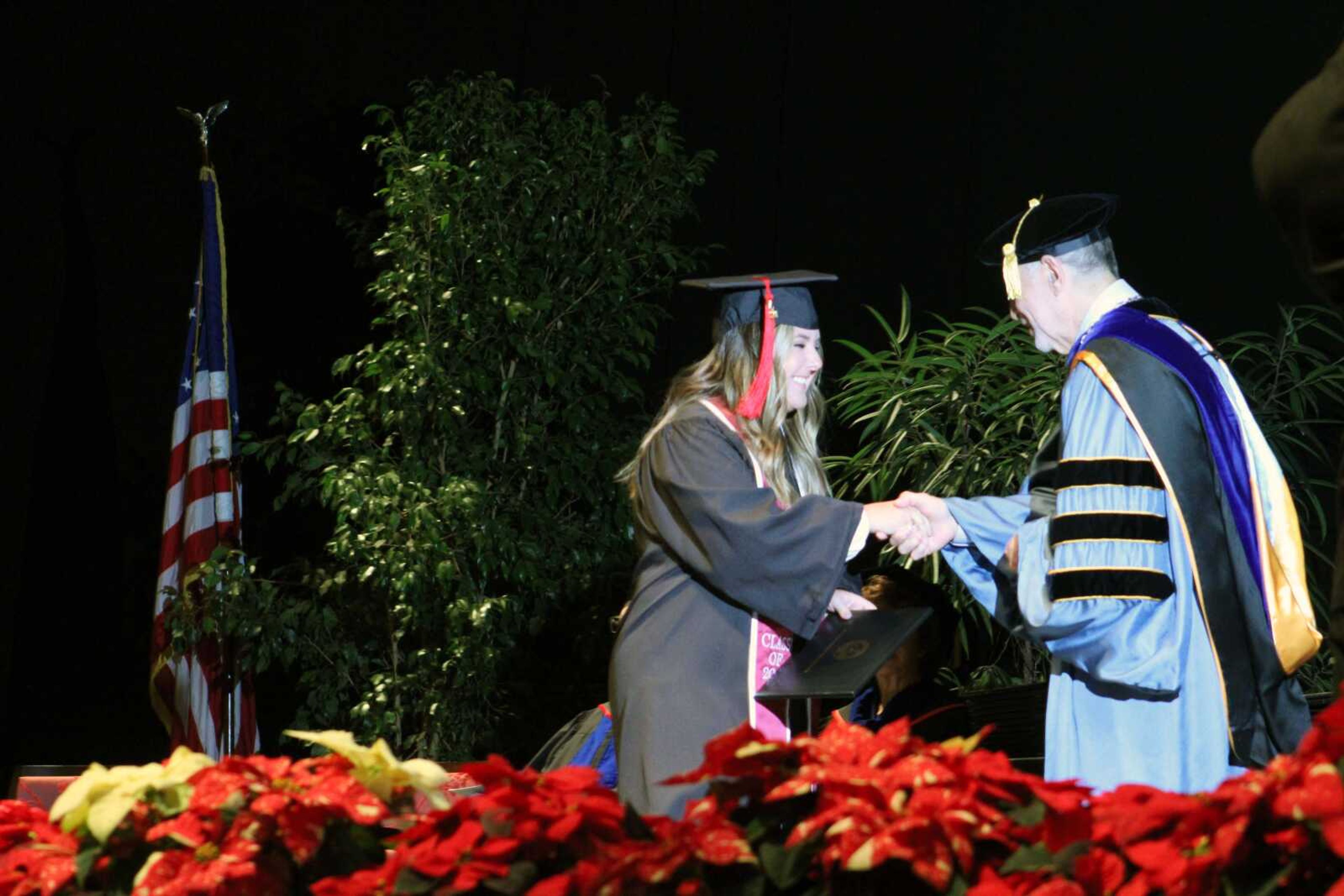 A Southeast Missouri State University graduate shakes hands with President Carlos Vargas while receiving her diploma during SEMO's 2021 Fall Commencement Ceremony Saturday afternoon at the Show Me Center in Cape Girardeau.