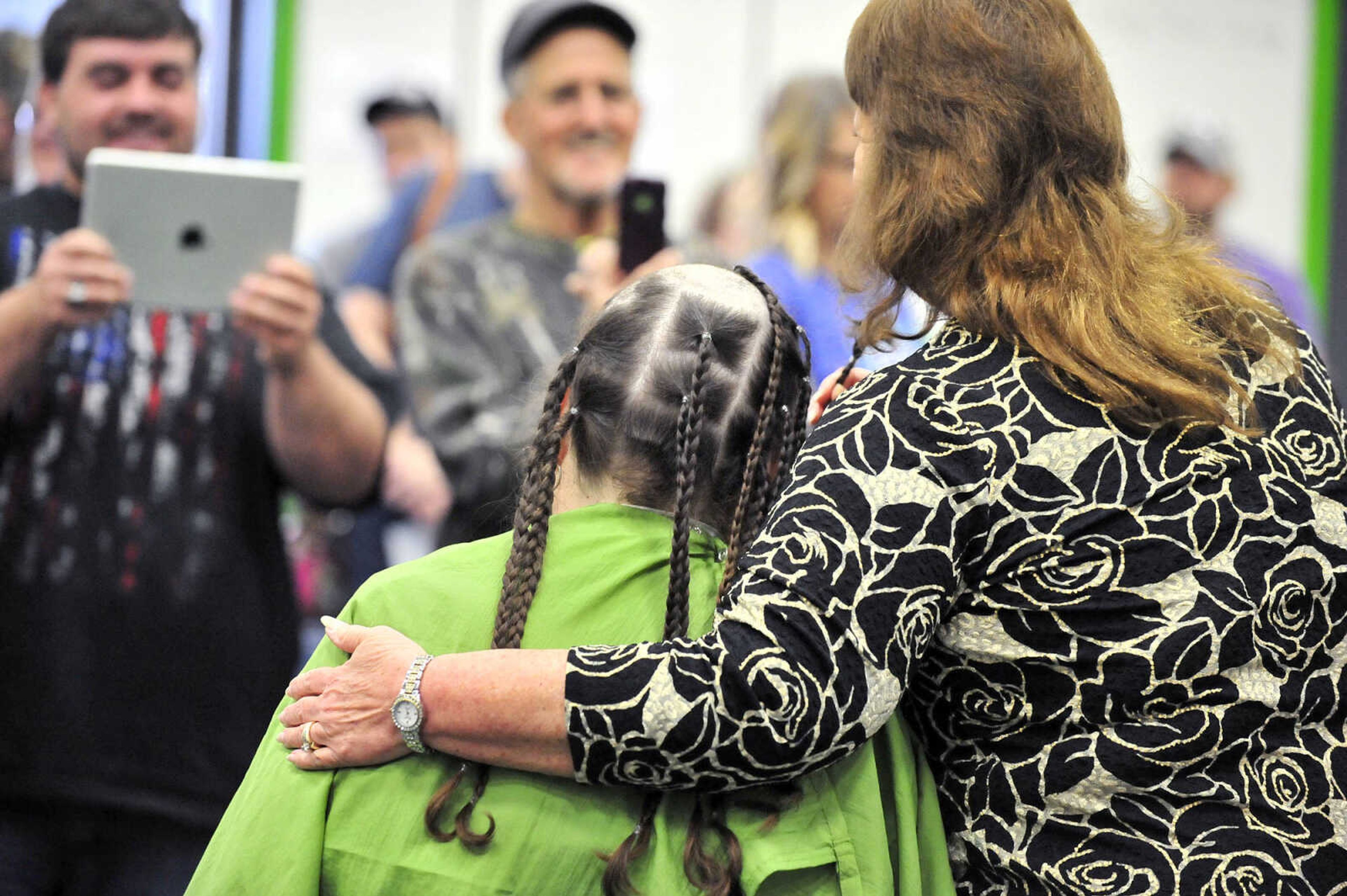 Ethan Jamieson, left, and Kirby Klaus take photos of Cathy Klaus and Lisa Jamieson on Saturday, March 4, 2017, during the St. Baldrick's Foundation fundraiser at Old Orchard CrossFit in Jackson.