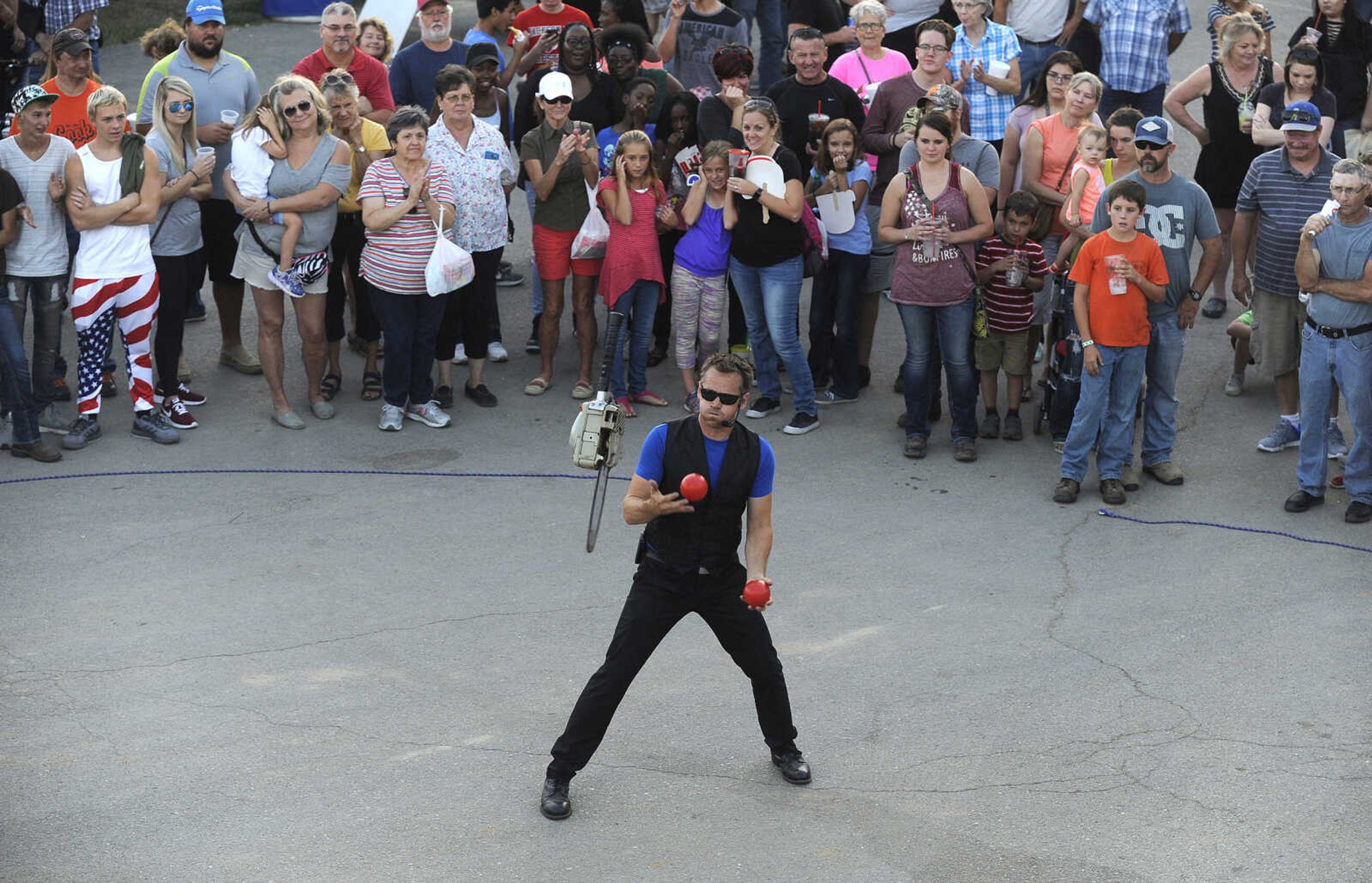 FRED LYNCH ~ flynch@semissourian.com
Wade Henry juggles two balls and a revving chainsaw in his strolling show Friday, Sept. 15, 2017 at the SEMO District Fair in Cape Girardeau.