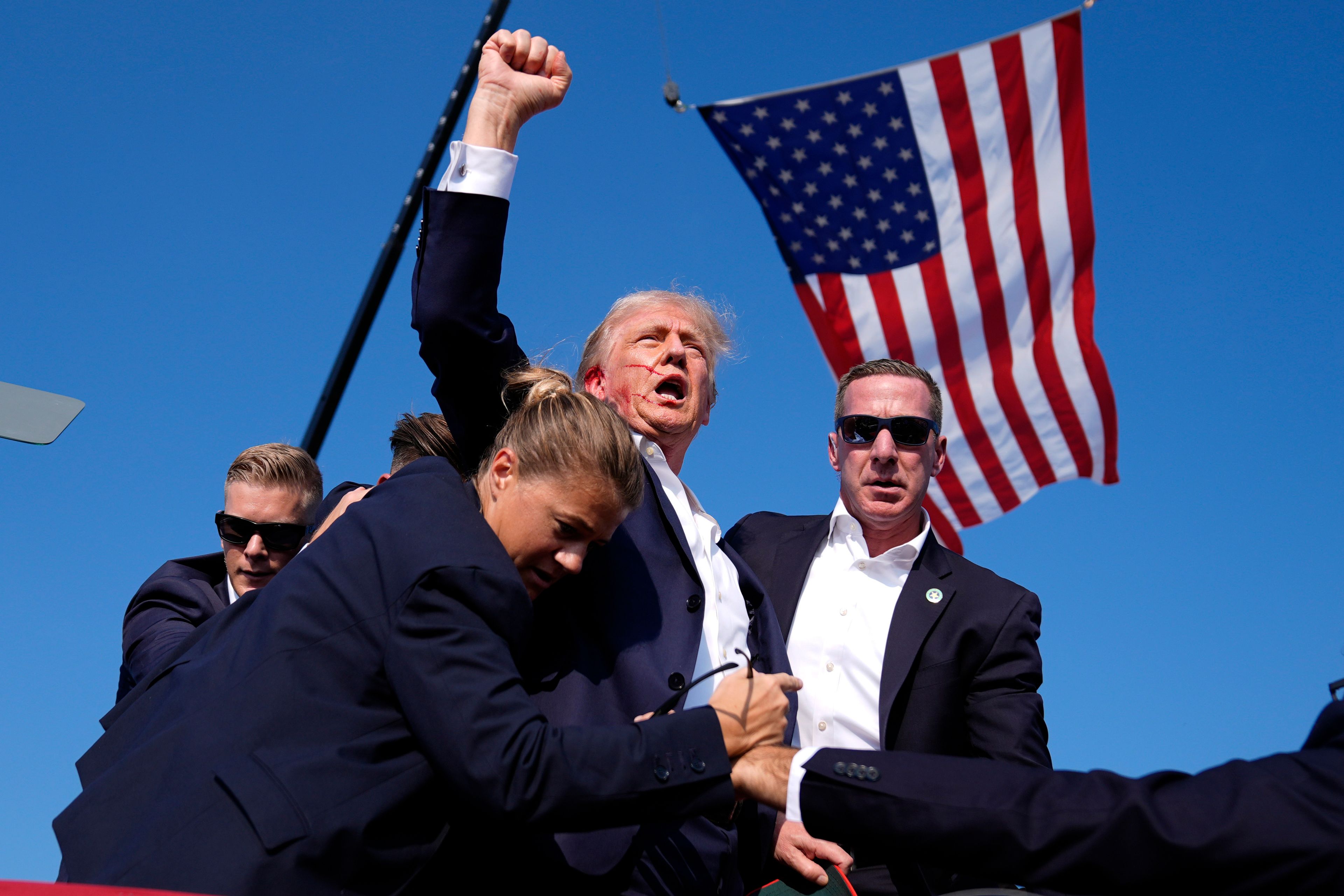 Republican presidential candidate former President Donald Trump is surrounded by U.S. Secret Service agents after an assassination attempt at a campaign rally in Butler, Pa., July 13, 2024. (AP Photo/Evan Vucci)