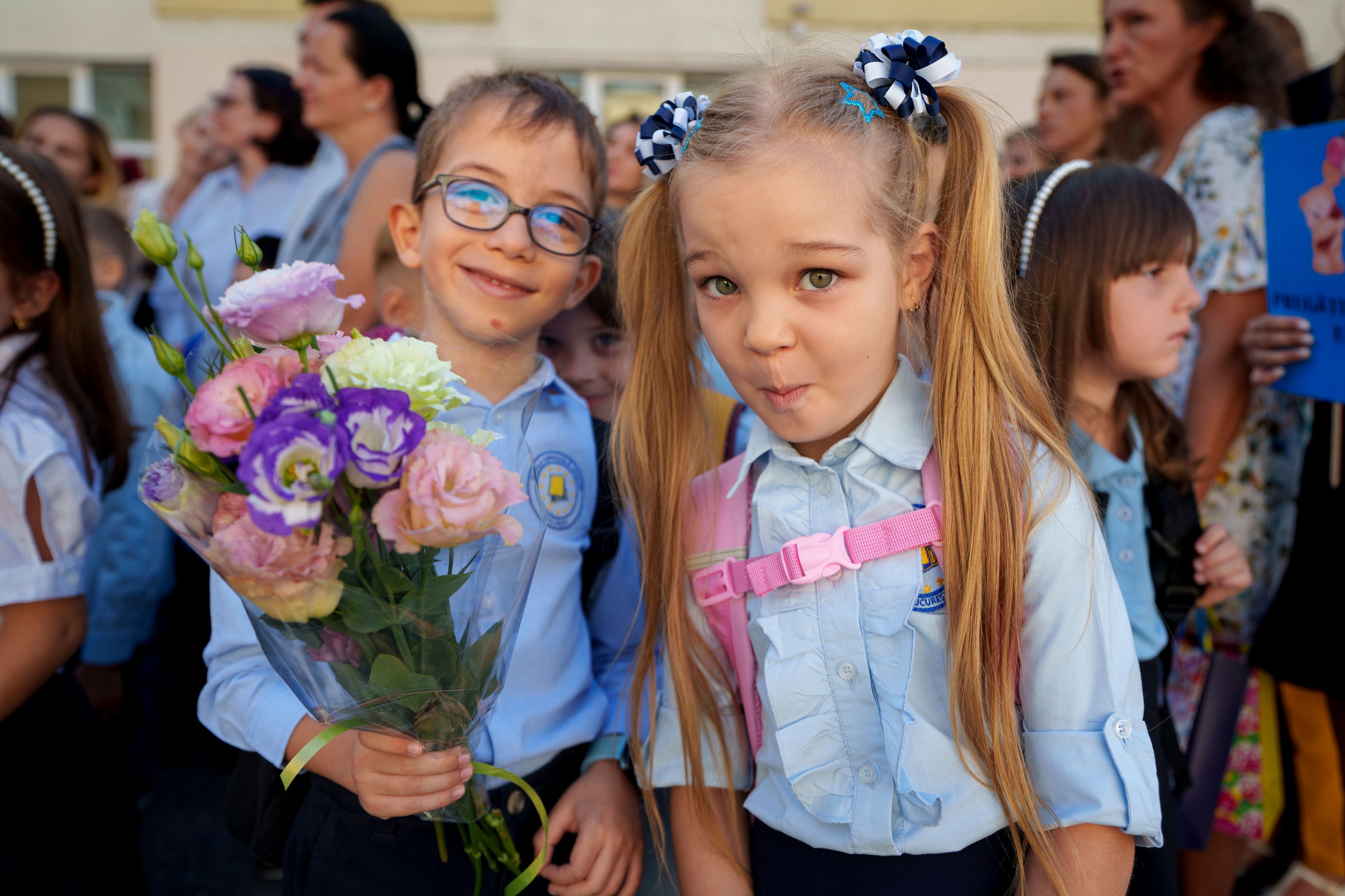 Astryd and Adam, 6 and a half years-old, strike a pose during a ceremony marking the beginning of the school year at the Orizont Elementary School in Bucharest, Romania, Monday, Sept. 9, 2024. (AP Photo/Vadim Ghirda)