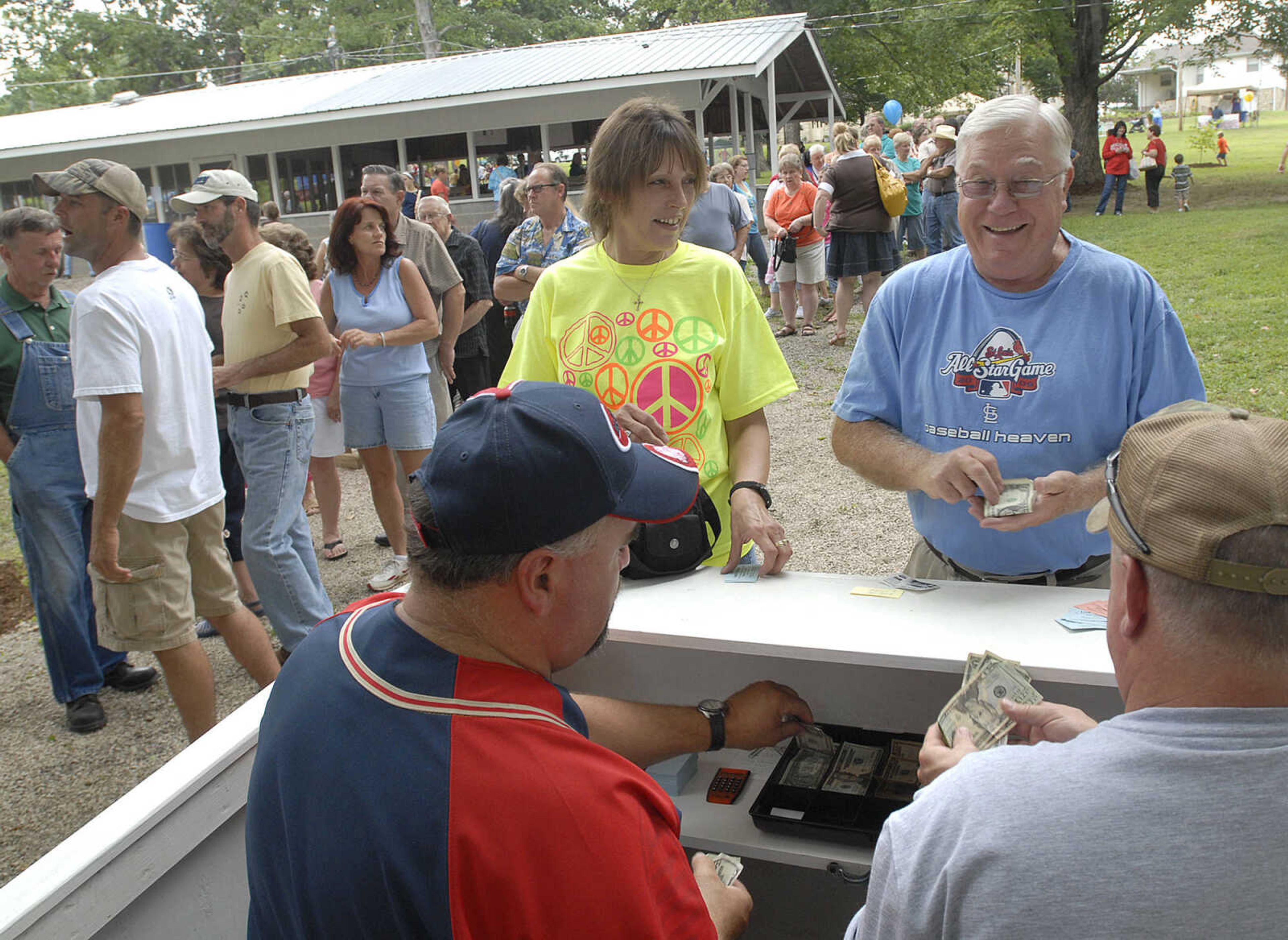 Carolyn Schreckenberg and Joe Carlisle buy dinner tickets from Ed Vandeven, left, and Tony Gemeinhardt at the Leopold Picnic.