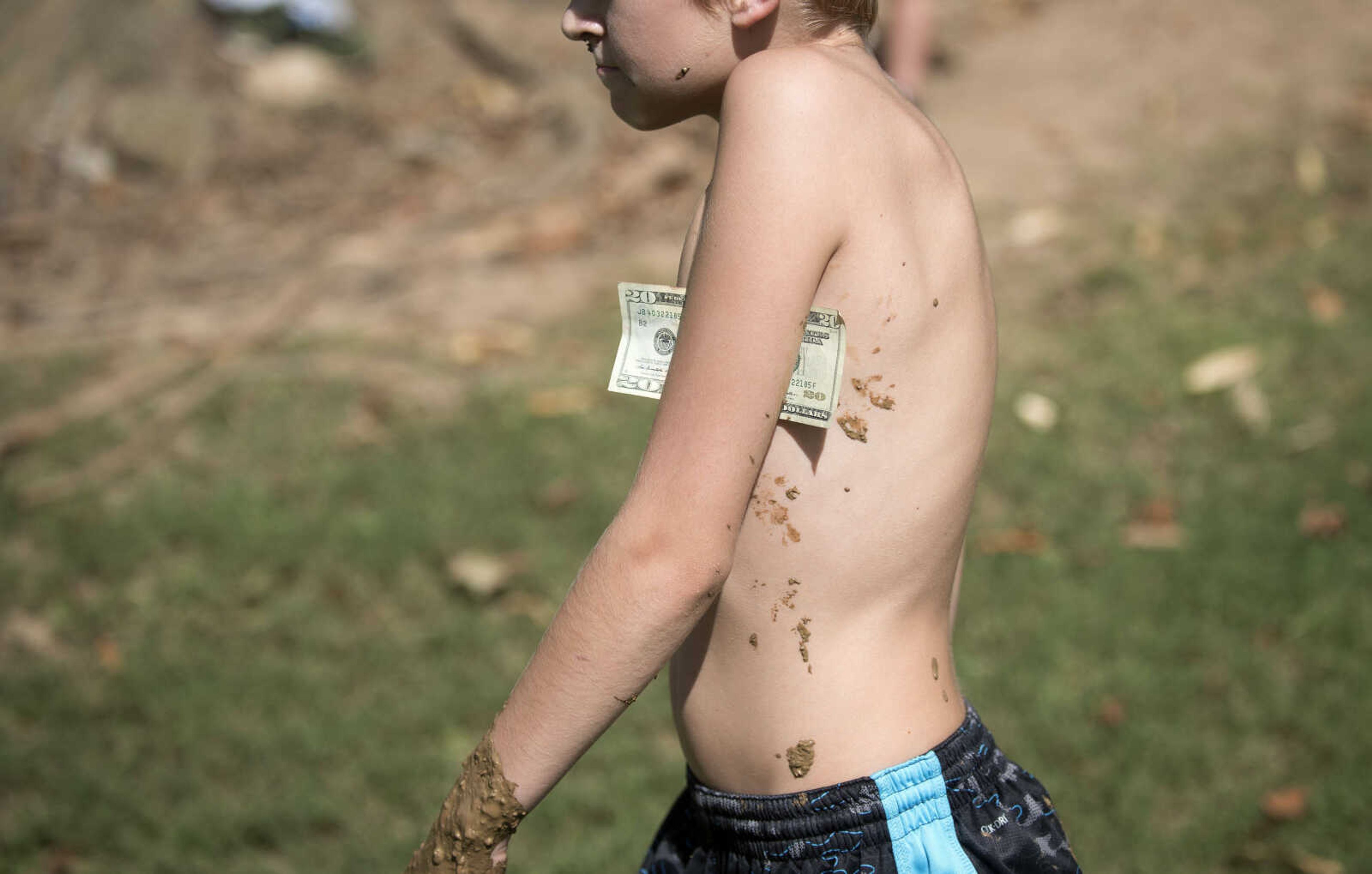 A mud-race winner keeps his spoils clean as he heads toward the hoses to rinse off during Benton Neighbor Days Saturday, September 1, 2018.