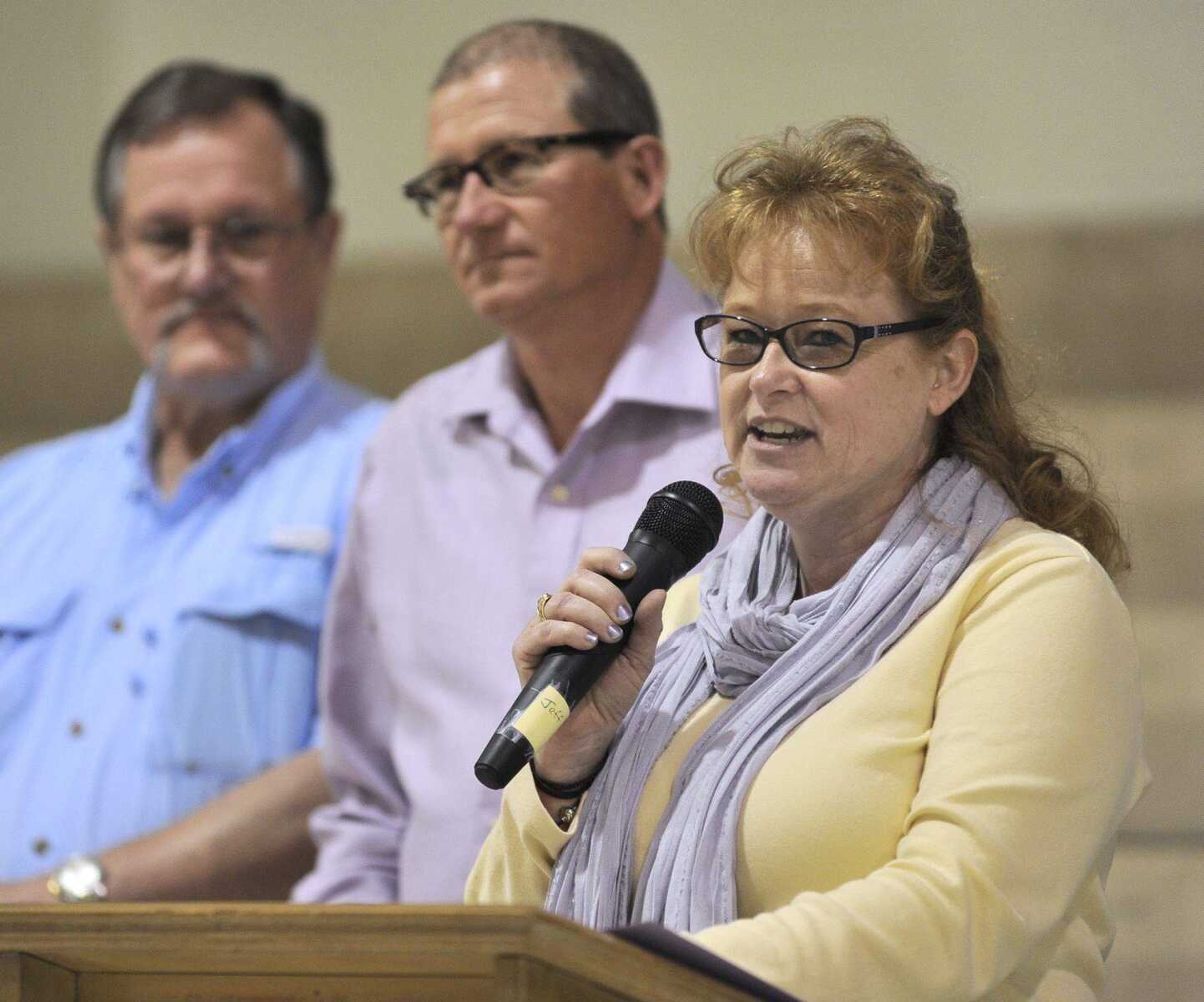 Diane Scherer-Morris speaks Sunday, April 13, 2014 at a gathering of friends and family of her sister, Cheryl Scherer, who disappeared in 1979. Her brother, Anthony Scherer, center, and husband, Ron Morris, stand nearby. (Fred Lynch)