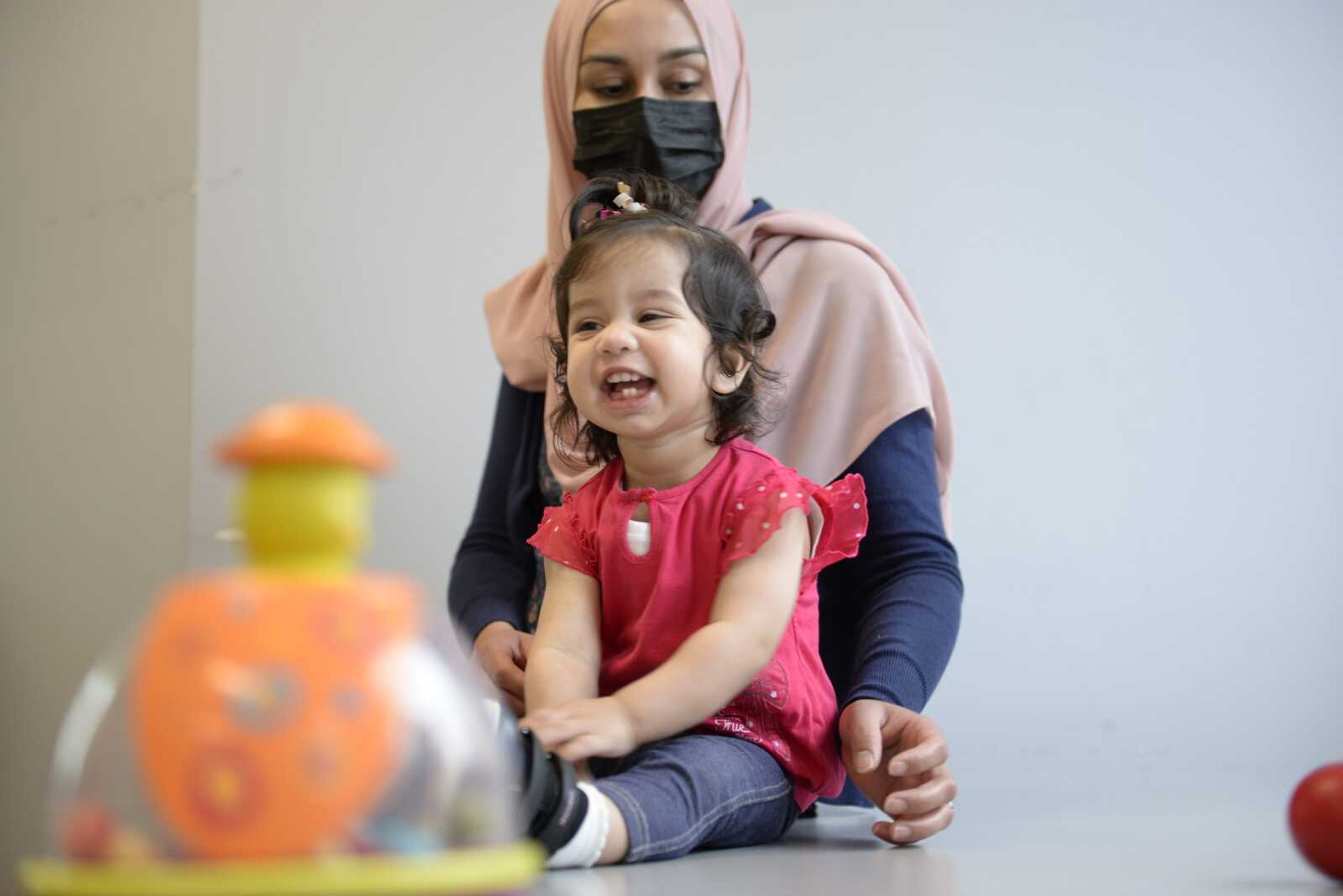 Ayla Bashir sits with her mother, Sobia Qureshi, during a physical therapy assessment for Ayla at Children's Hospital of Eastern Ontario on Aug. 23 in Ottawa. The toddler is the first child treated as a fetus for Pompe disease, an inherited and fatal disorder in which the body fails to make some or all of a crucial protein.