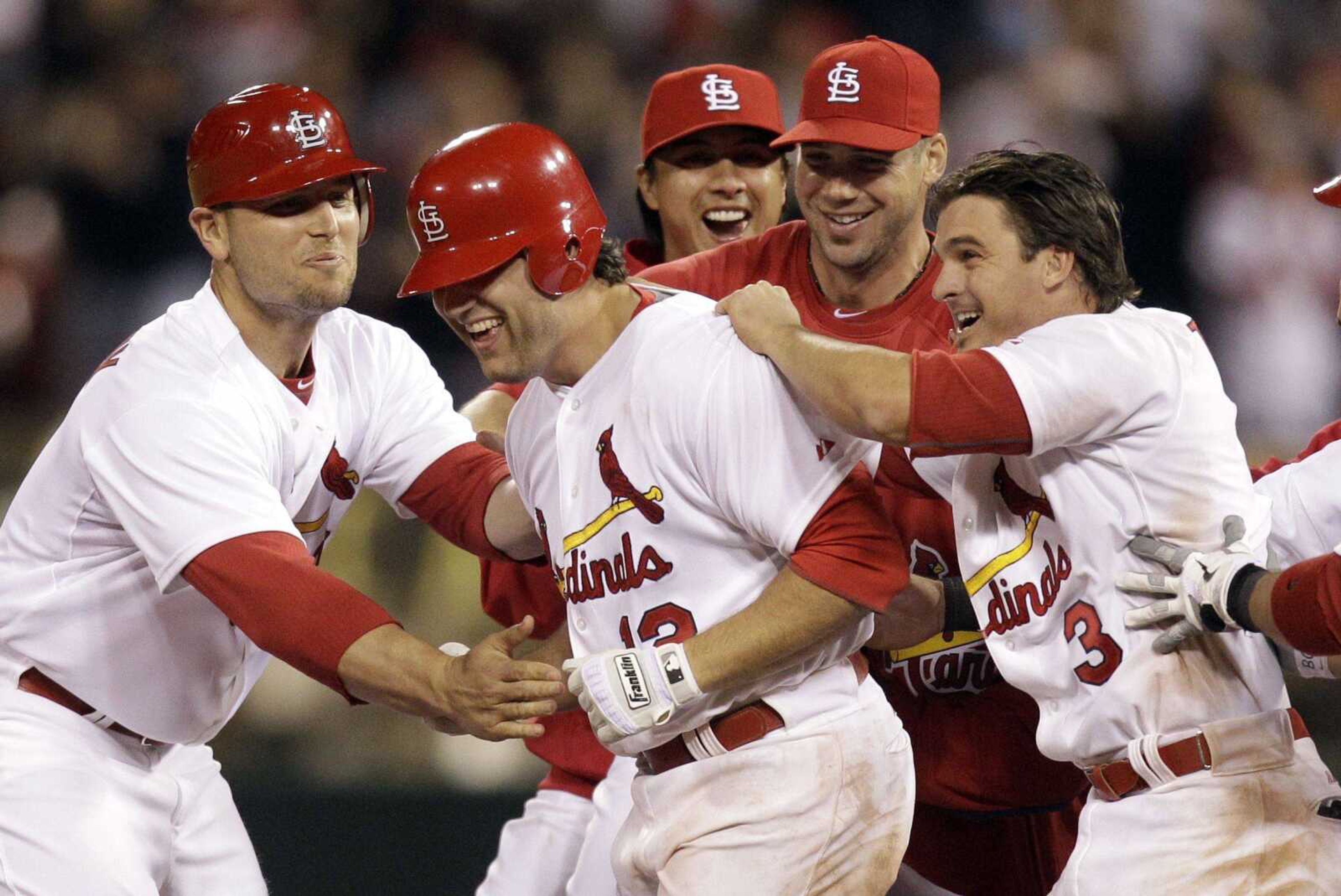 Cardinals outfielder Lance Berkman is mobbed by teammates, from left, Matt Holliday, Kyle Lohse, Chris Carpenter and Ryan Theriot after hitting a walk-off single to defeat the Phillies during a game in May. Berkman has regained his old form after the Cardinals signed him to a one-year free agent deal last winter. (JEFF ROBERSON ~ Associated Press)