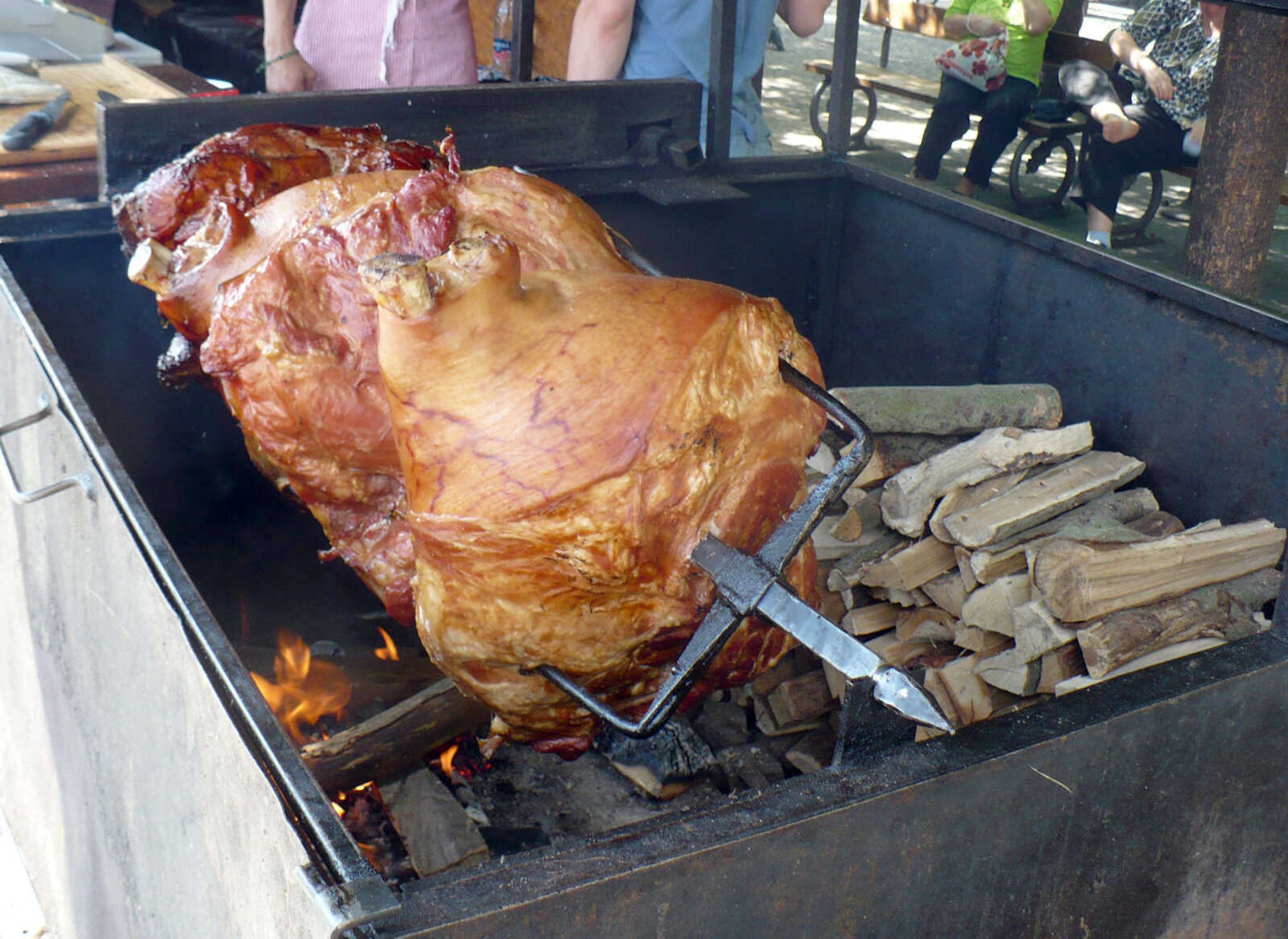 A side of pork cooking on a spit on the street in Prague's old town square.