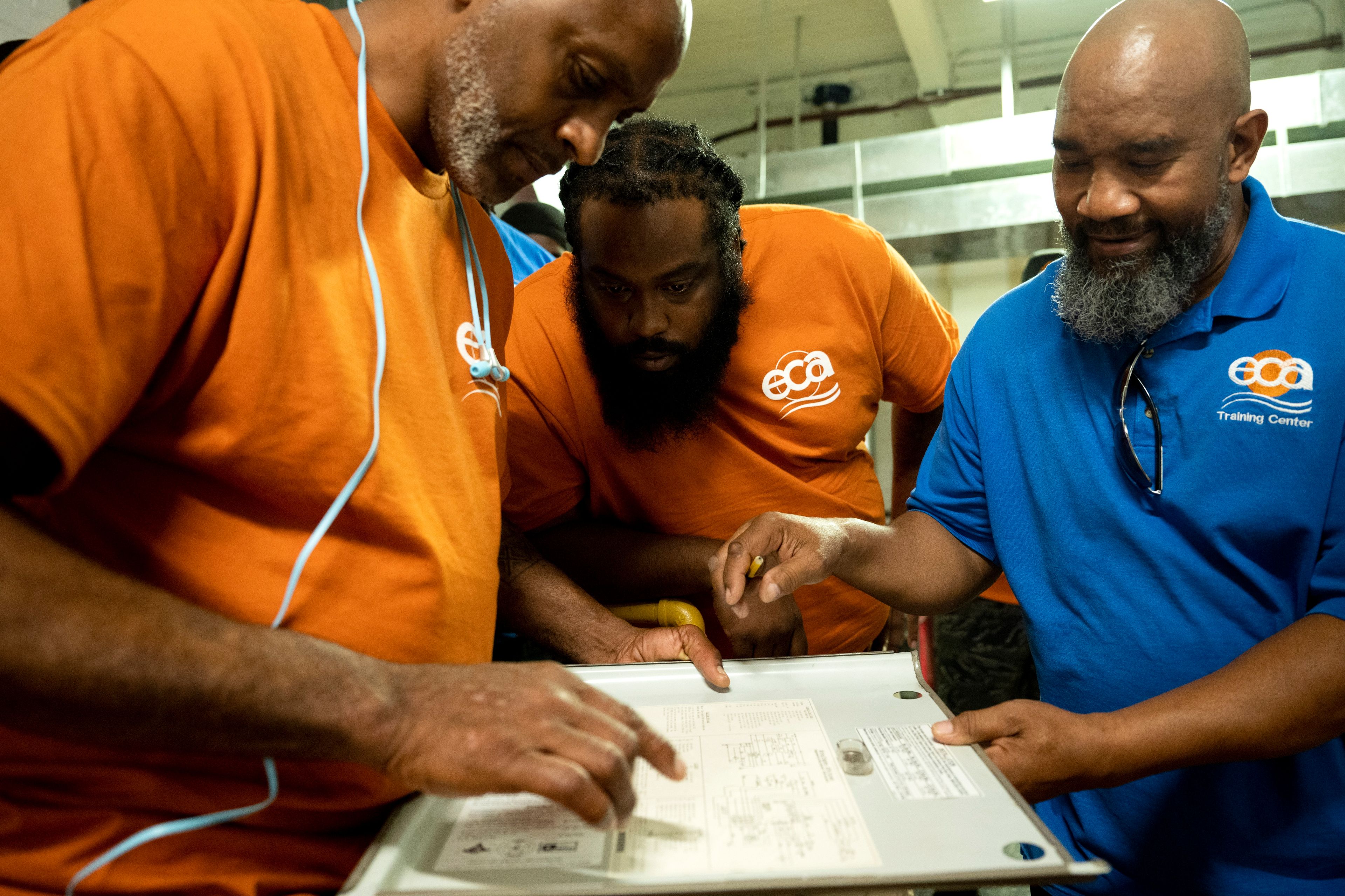 Jackie Robinson, right, an instructor at the Energy Coordinating Agency, a nonprofit focused in part on energy equity, teaches a class at the facility on Tuesday, July 2, 2024, in Philadelphia. (AP Photo/Joe Lamberti)