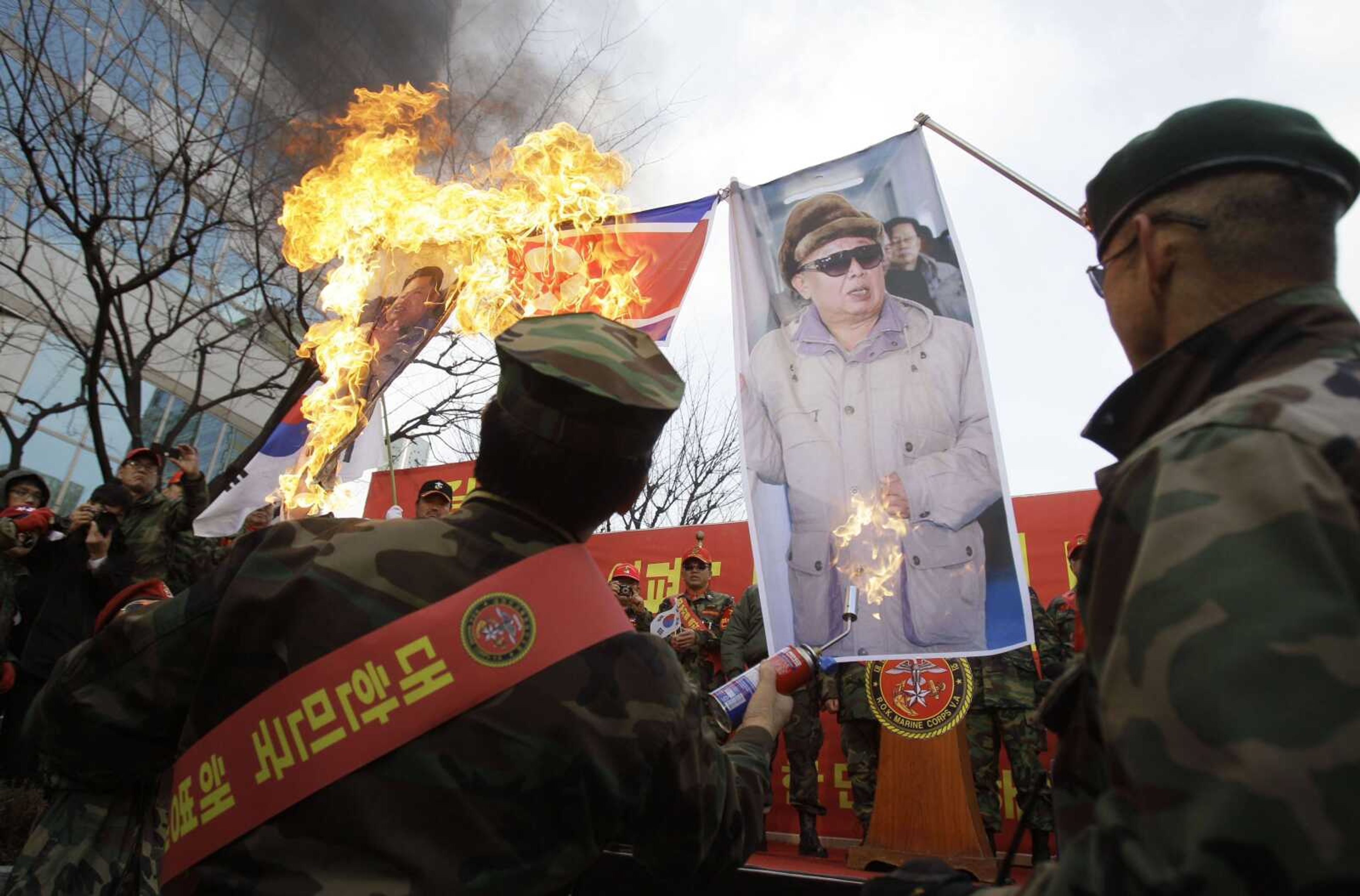 Former South Korean marines burn images of North Korean leader Kim Jong Il, right, and his son, Kim Jong Un, during a rally Saturday denouncing North Korea in Seoul, South Korea. (Wally Santana ~ Associated Press)