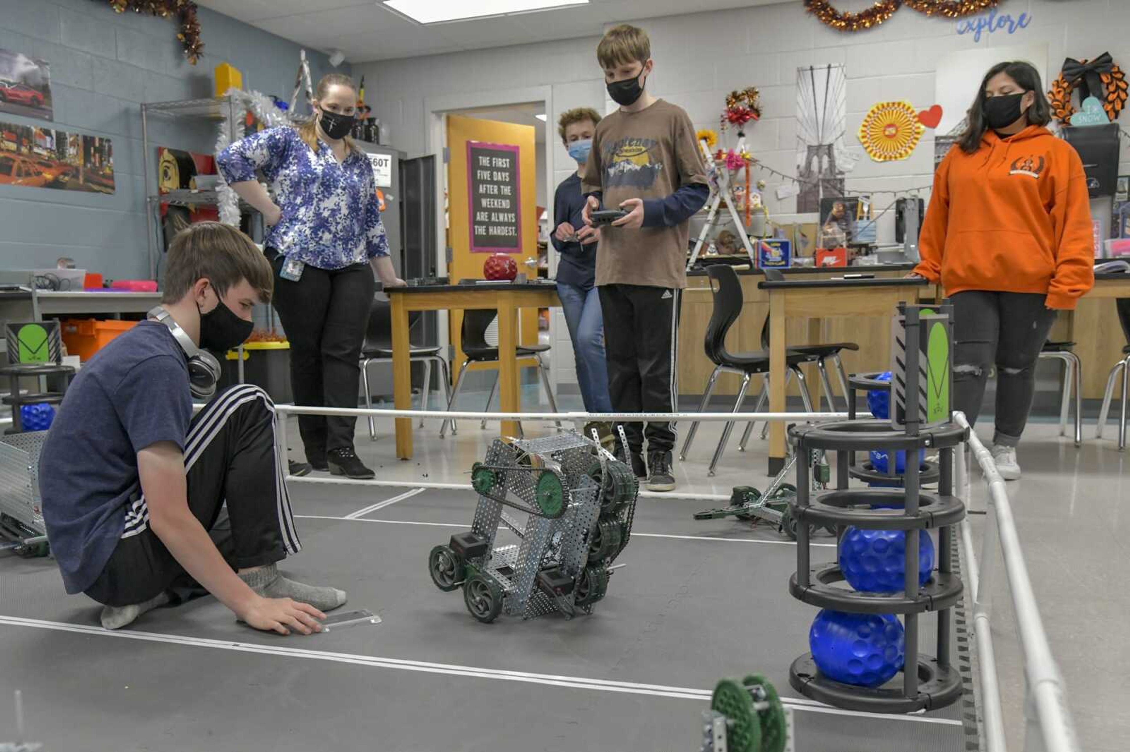 Students of the TigerTech robotics club at Cape Girardeau Central Junior High School and team coach and teacher Julianna West, left, watch Tuesday as they test the robot they plan to take to the Missouri Middle School VEX State Championship this weekend.