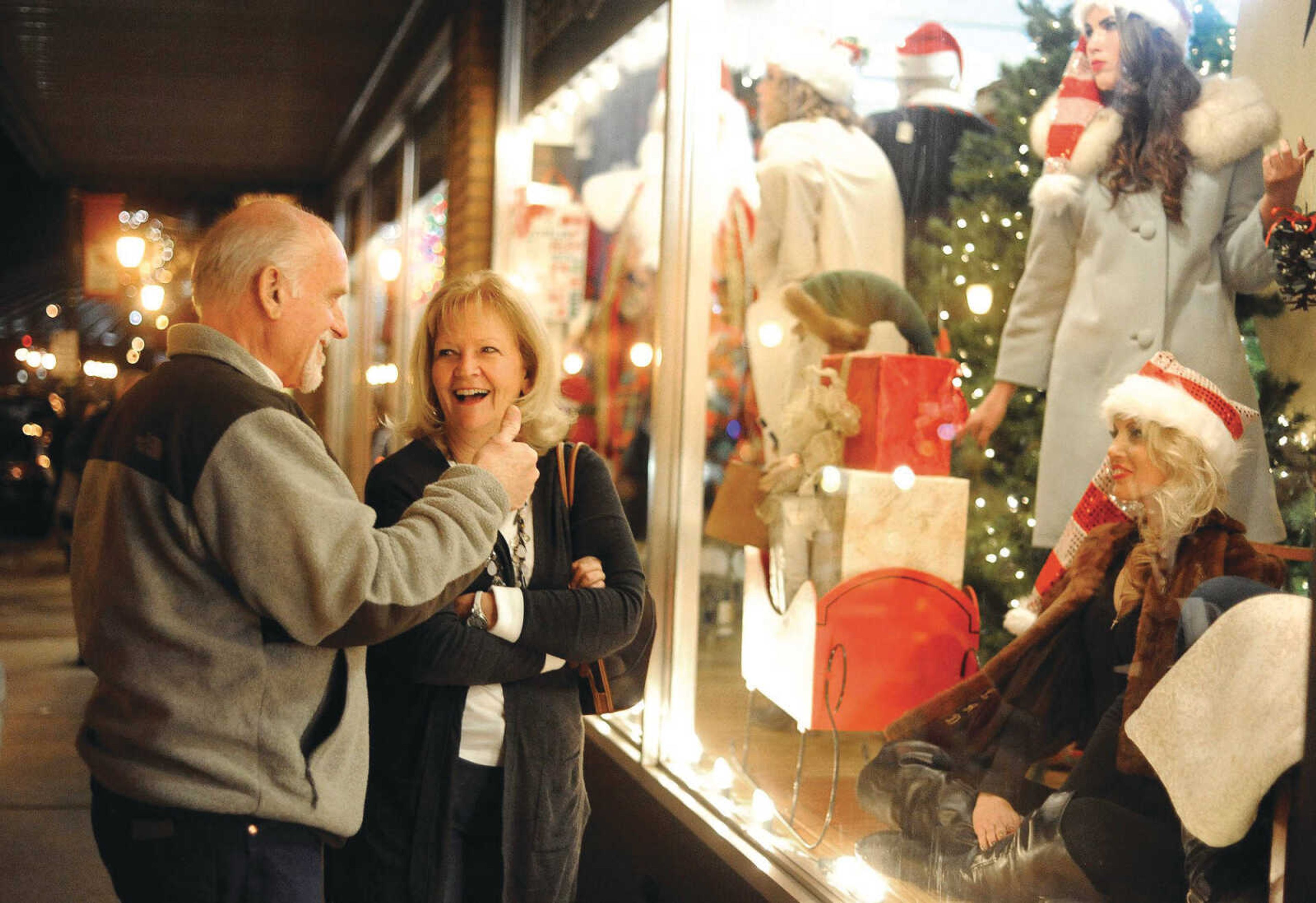 Kay Thompson laughs as her husband, Stan, gives the models in the live window display at Pastimes Antiques a thumbs-up Dec. 4 during Old Town Cape's annual Downtown Christmas Open House in Cape Girardeau.