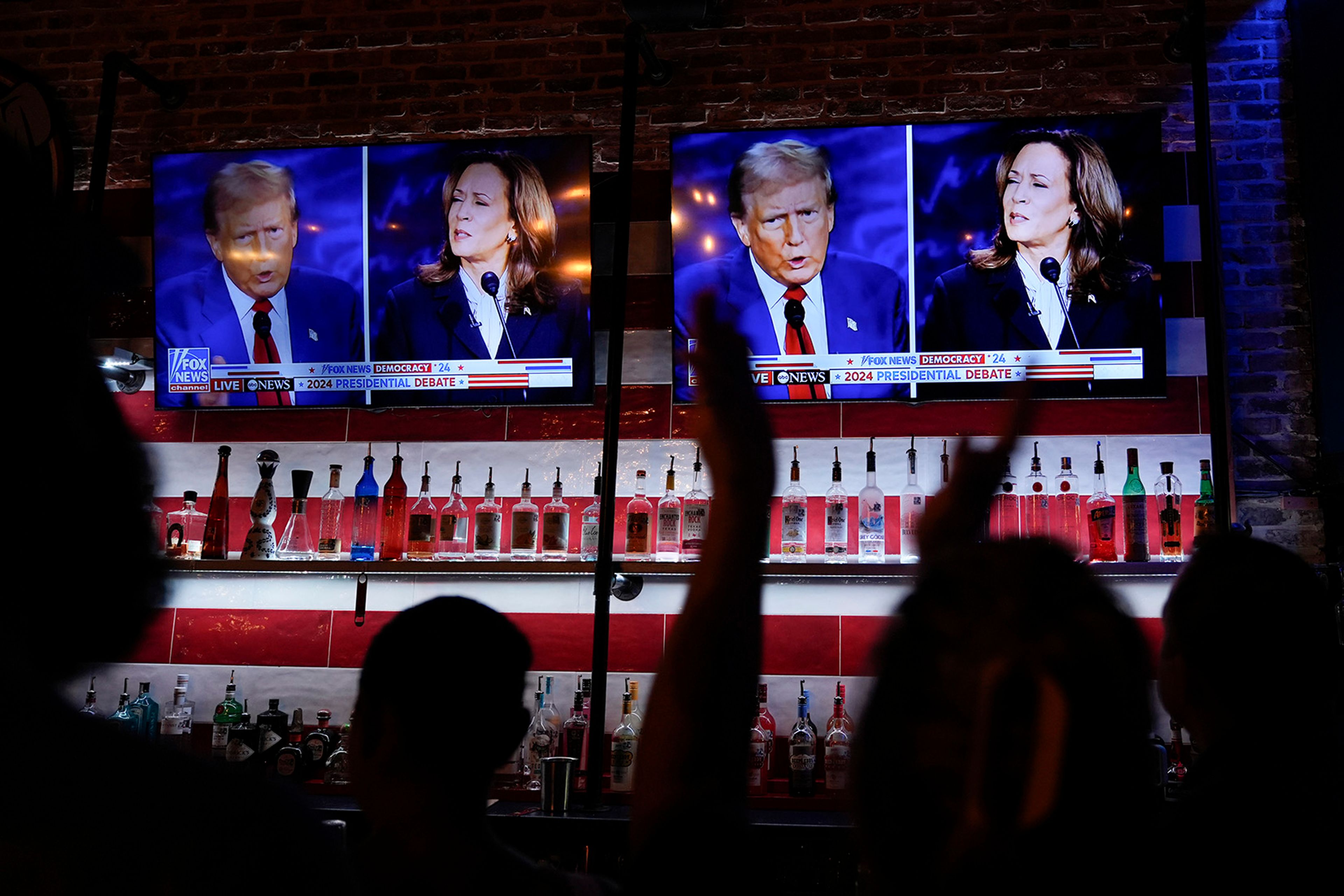 Viewers cheer as they watch a debate between Democratic presidential nominee Vice President Kamala Harris and Republican presidential nominee former President Donald Trump at the Angry Elephant Bar and Grill, Tuesday, Sept. 10, 2024, in San Antonio.