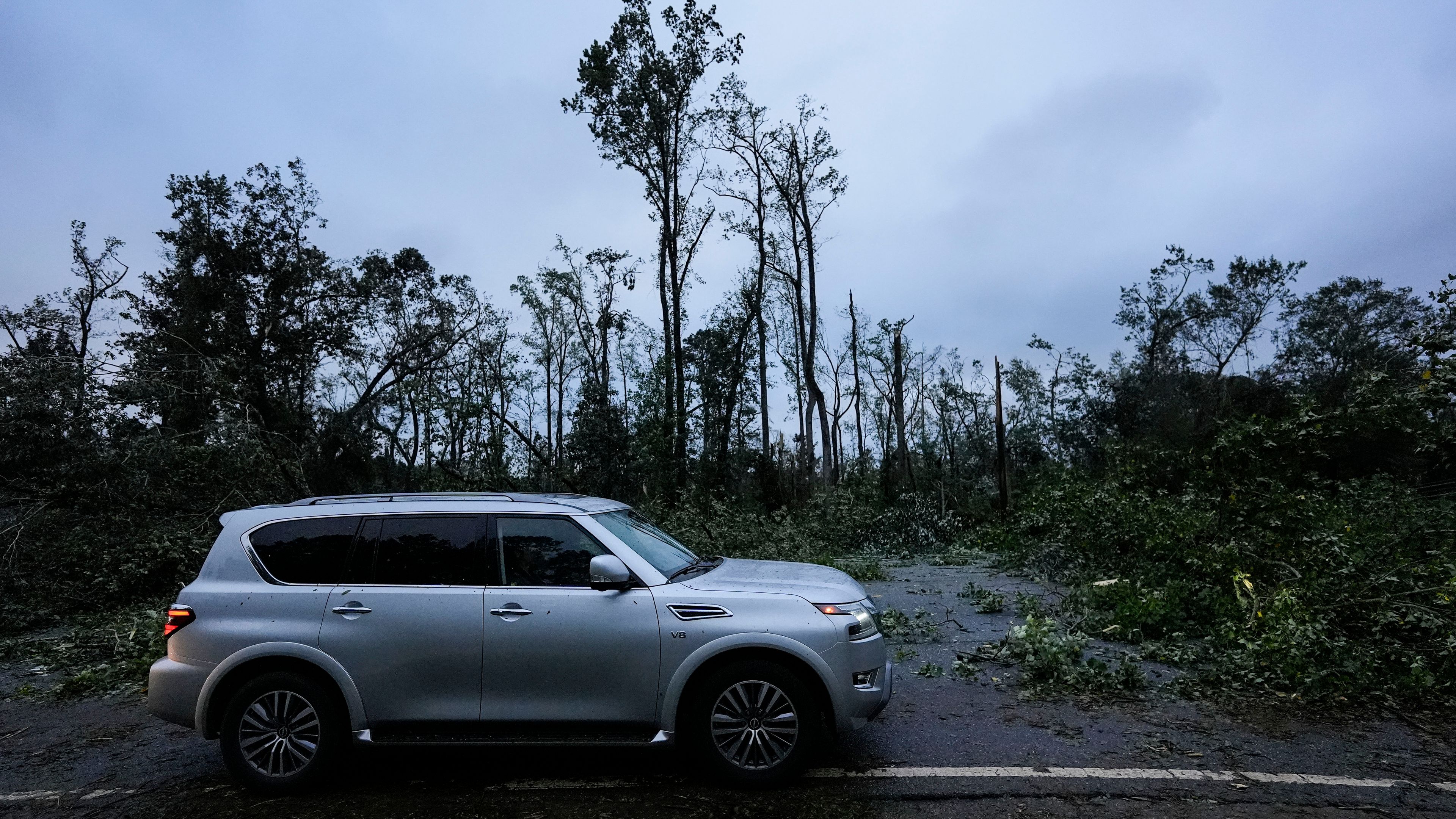 Vehicles move slowly around trees that have fallen after Hurricane Helene moved through the area, Friday, Sept. 27, 2024, in Valdosta, Ga. (AP Photo/Mike Stewart)