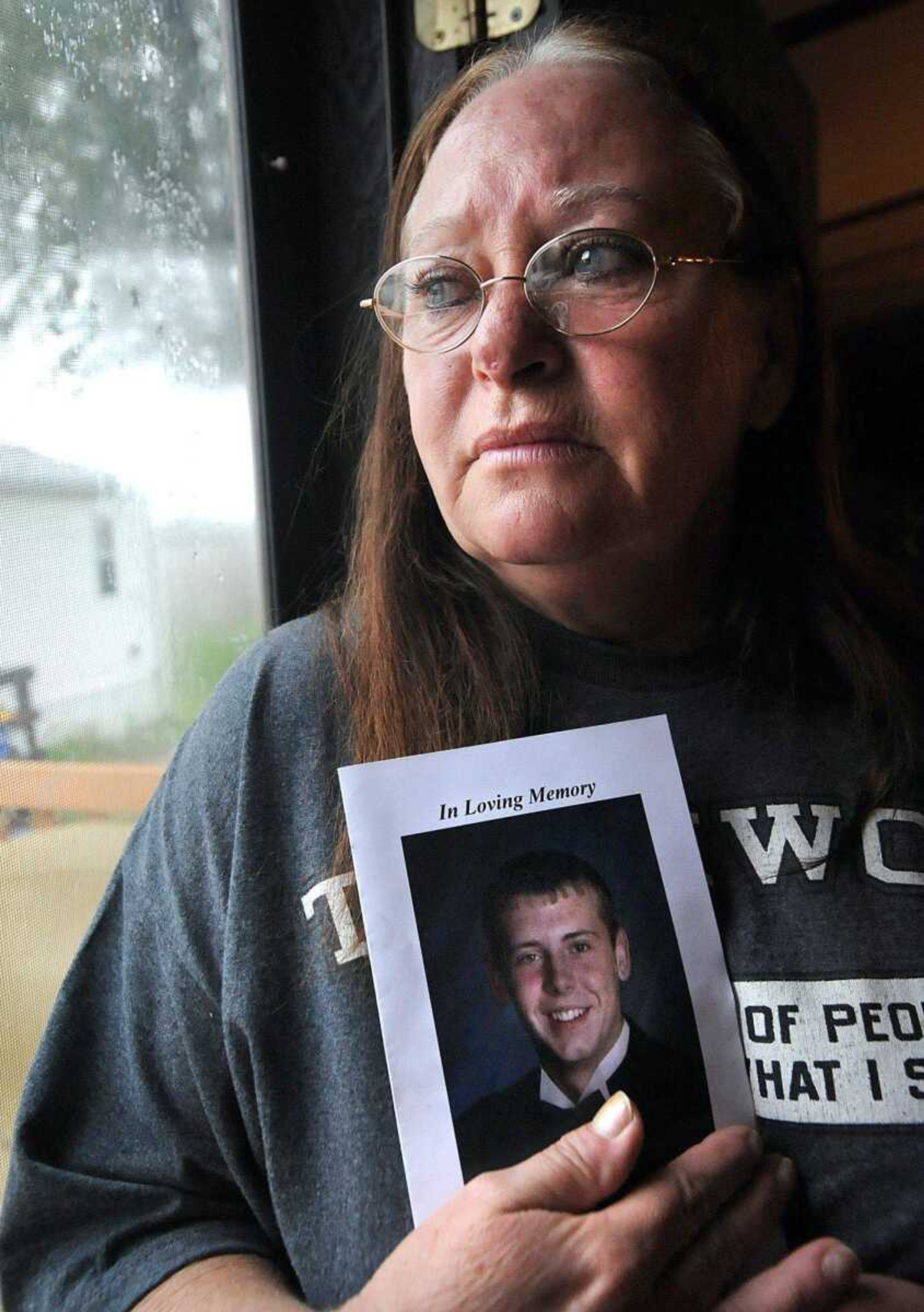 Mona Buck of Cape Girardeau, holds a memoriam of her stepson, Donovan Buck, 29, inside her home Sunday. Donovan Buck was stabbed to death Sept. 1 in Des Arc, Ark. (Laura Simon)