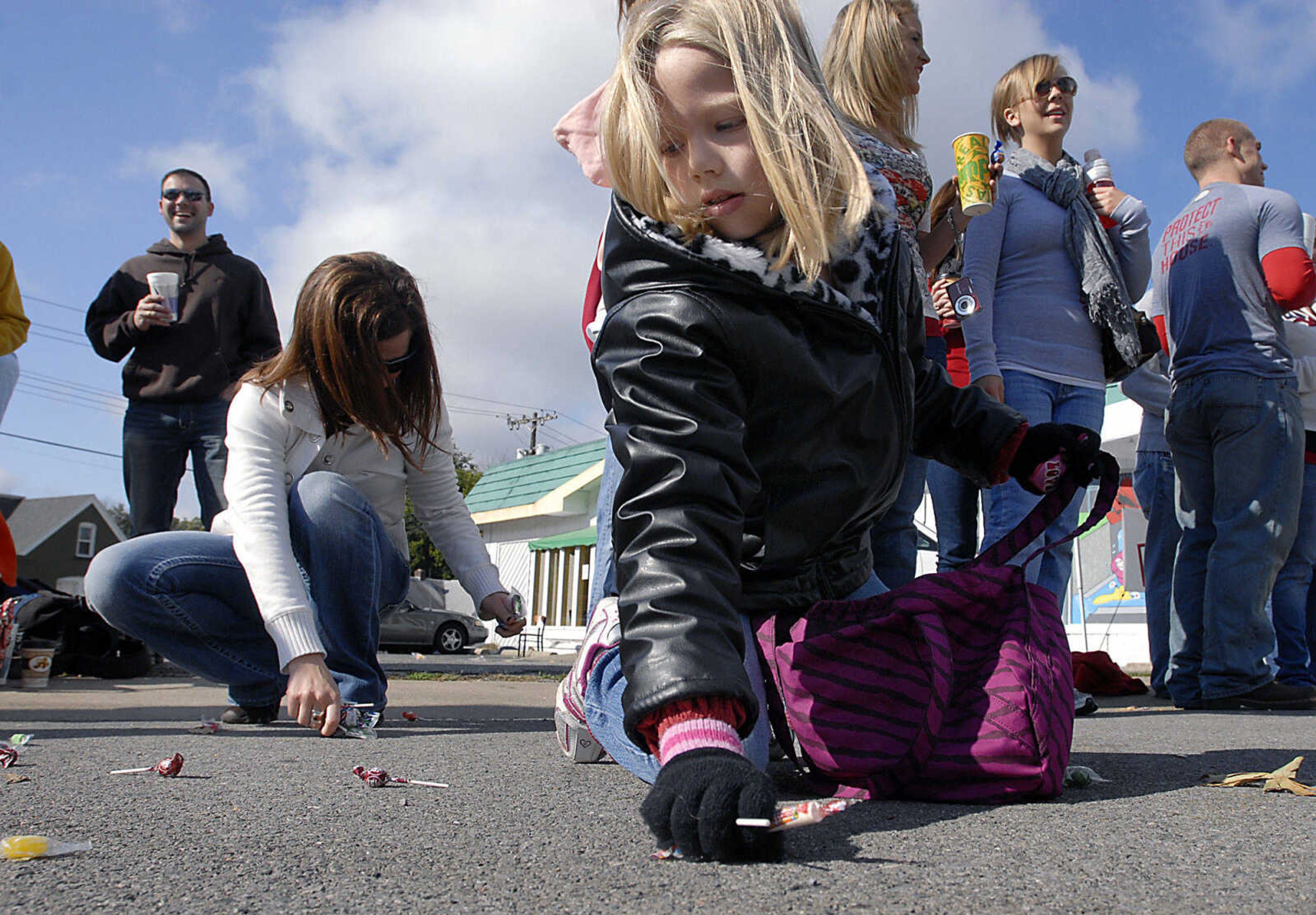 KIT DOYLE ~ kdoyle@semissourian.com
Morgan Hessenkemper, 7, collects candy as her aunt Rachel Bertrand helps Saturday morning, October 10, 2009, during the Southeast Missouri State Homecoming parade along Broadway in Cape Girardeau.