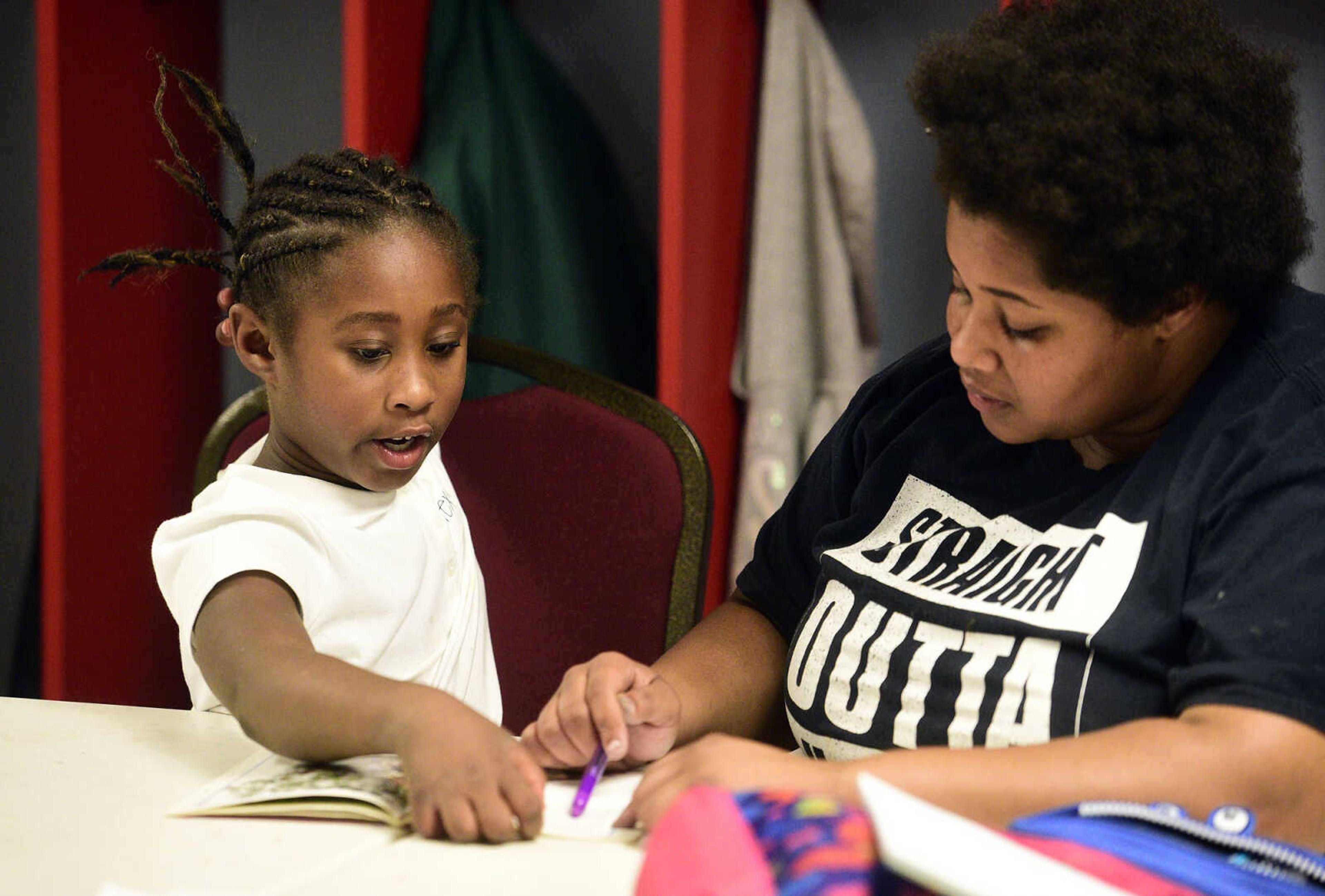 Cherish Moore, right, helps Alexya Jones read through her book on Monday, Aug. 14, 2017, during the Salvation Army's after school program at The Bridge Outreach Center in Cape Girardeau.