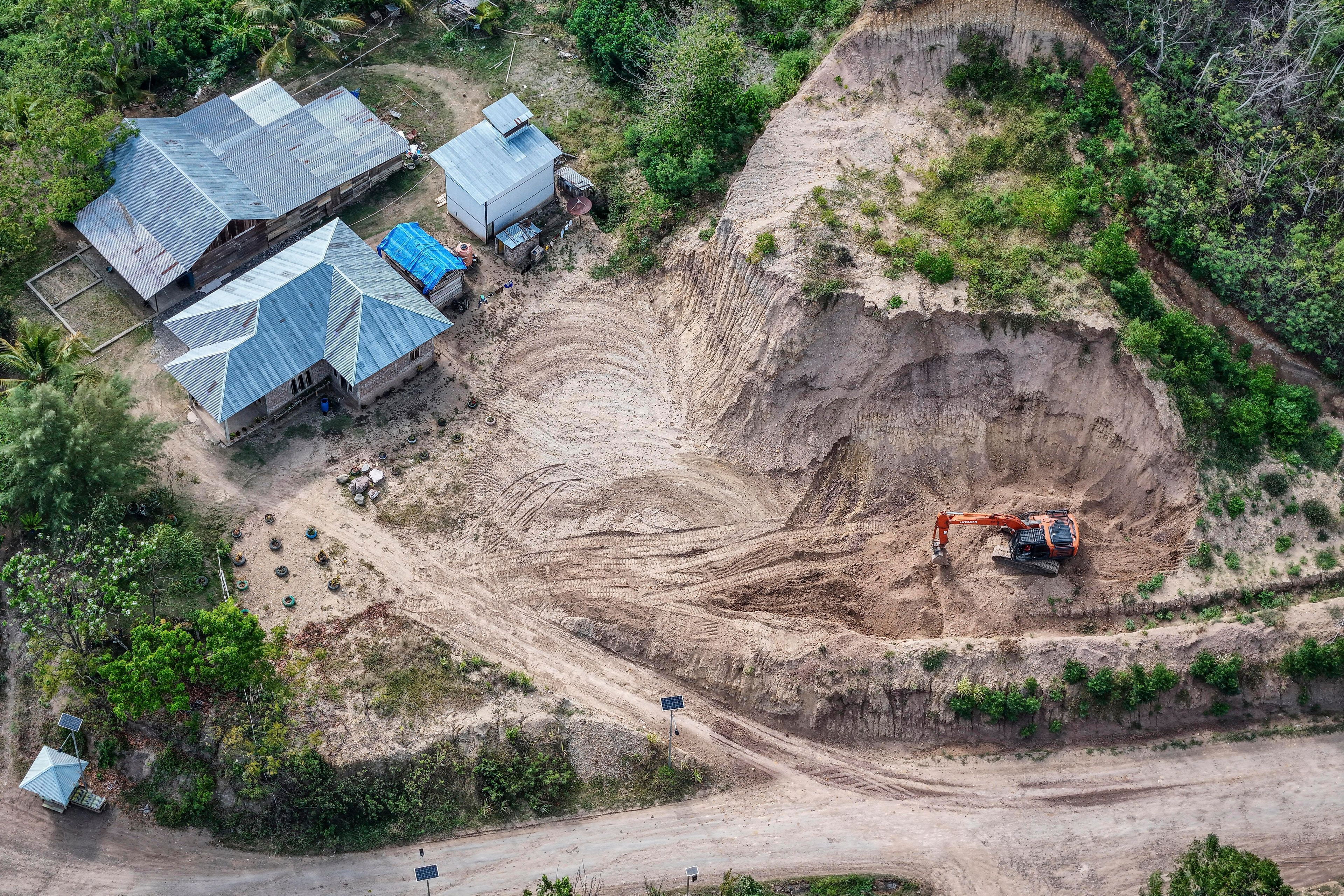 A machine operates near a road leading to the area of wood pellet production companies in Pohuwato, Gorontalo province, Indonesia, Tuesday, Oct. 22, 2024. (AP Photo/Yegar Sahaduta Mangiri)