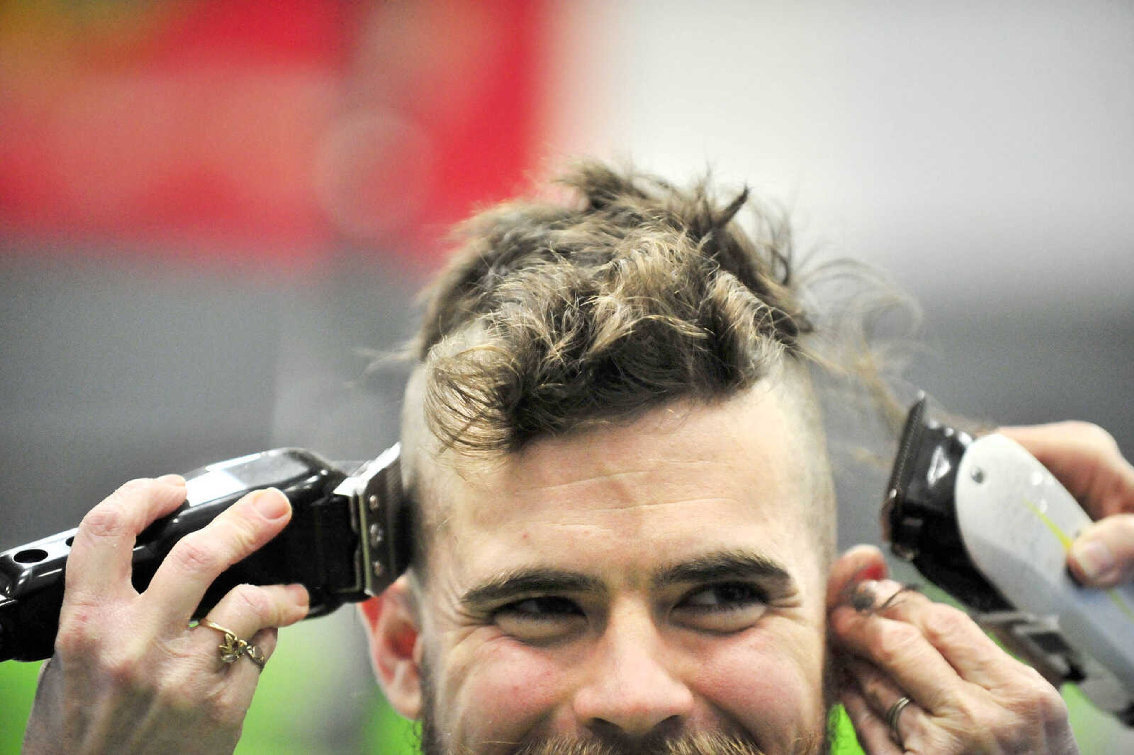 David Mincemeyer looks up as mother and daughter duo April Whiteside, left, and Jean McLane, right, shave Mincemeyer's head in unison  on Saturday, March 4, 2017, during the St. Baldrick's Foundation fundraiser at Old Orchard CrossFit in Jackson.