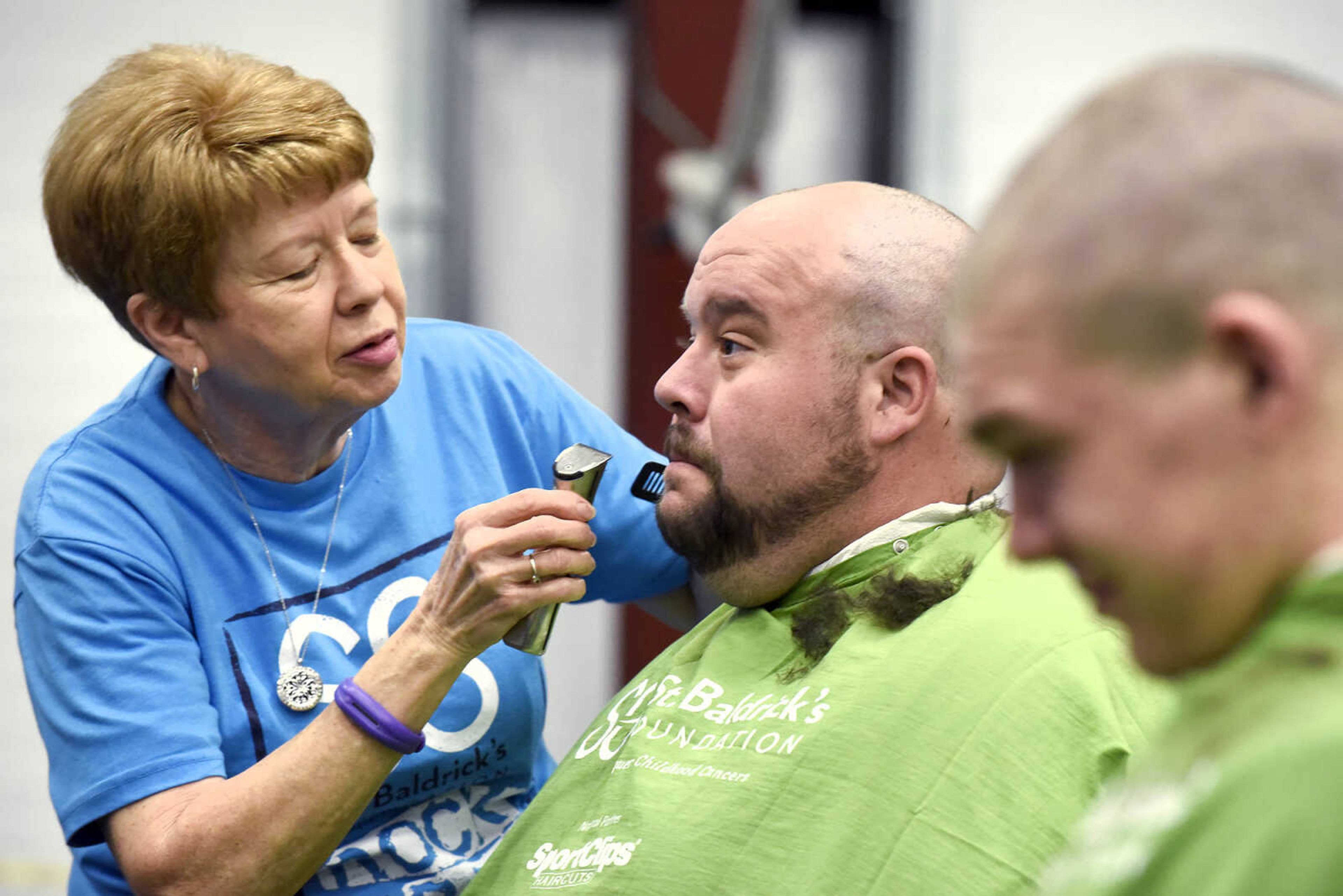 Joe Moss laughs as Jean McLane shaves his head on Saturday, March 4, 2017, during the St. Baldrick's Foundation fundraiser at Old Orchard CrossFit in Jackson.