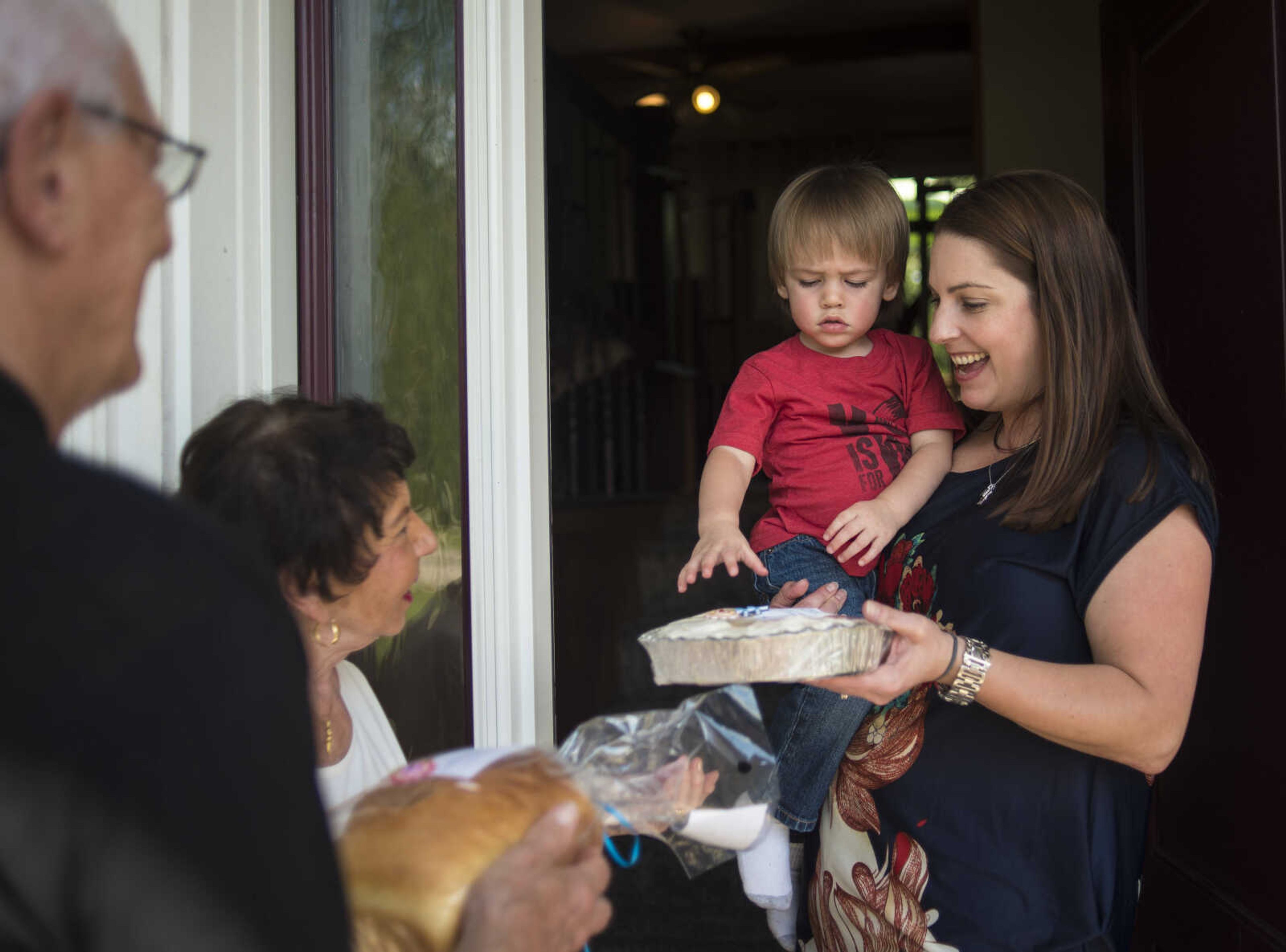 Betty Lou and Don Vogel hand deliver sourdough cinnamon rolls and bread to their neighbors, Meghan Tyson and her son Alex Tyson, Monday, Oct. 9, 2017 in Cape Girardeau.