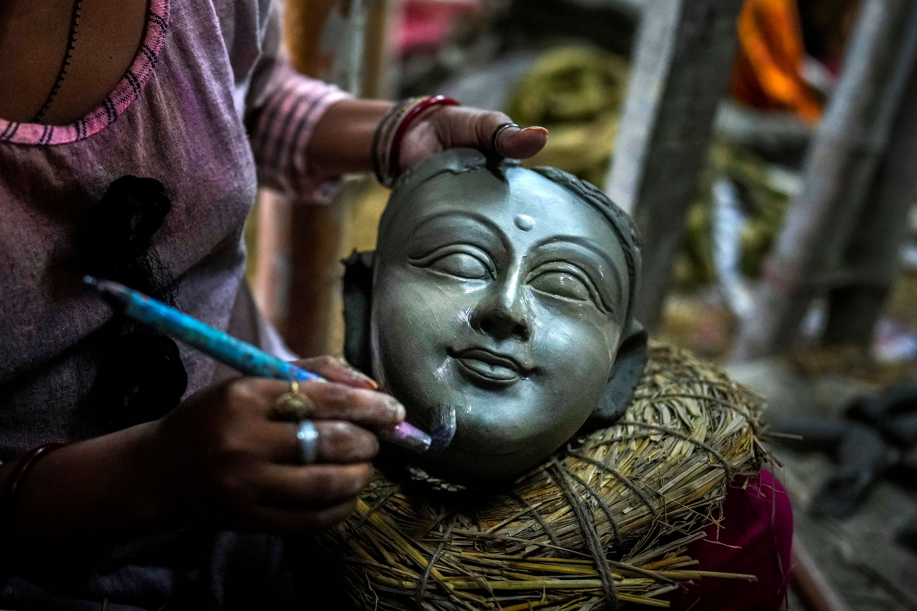 Sunita Paul, 31, gives finishing touches to a head meant for a mud idol of the Hindu goddess Durga at a workshop ahead of the Durga Puja festival in Guwahati, India, Wednesday, Oct. 2, 2024. (AP Photo/Anupam Nath)