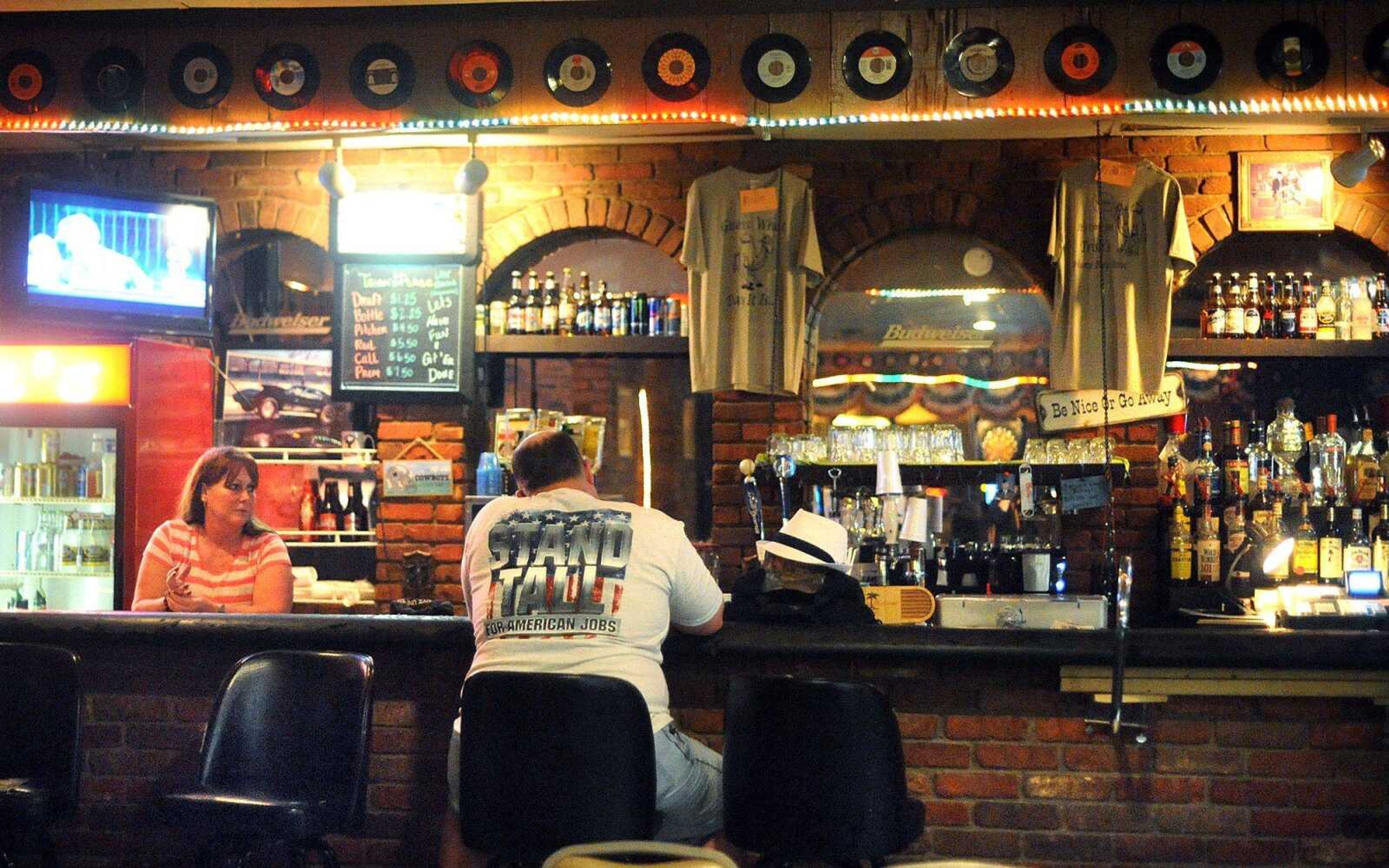 DJ James Jasinski sits at the bar as Sabrina Hardy, co-owner of Trish's Place, stands behind it after closing for the final time Saturday at its location west of the former Plaza Galleria in Cape Girardeau. More photos are in a gallery at<i> semissourian.com</i>. (Laura Simon)