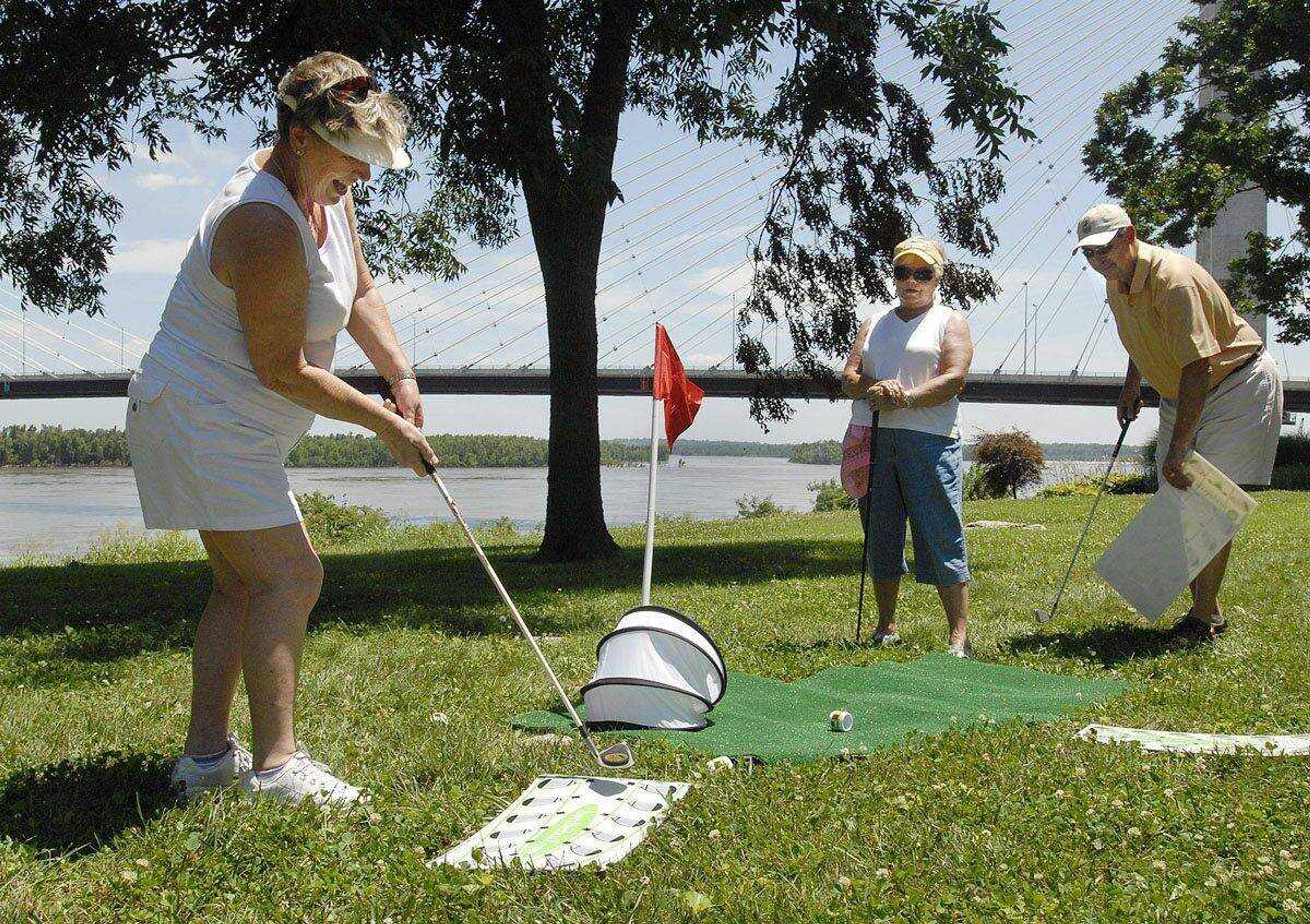 Trisha Kell strokes a BirdieBall to the green at the River Campus as Phyllis Duden and George Ganske watch June 29, 2009, during the First-Ever Fourth Annual Louis J. Lorimier Memorial World-Famous Downtown Golf Tournament. (Fred Lynch)