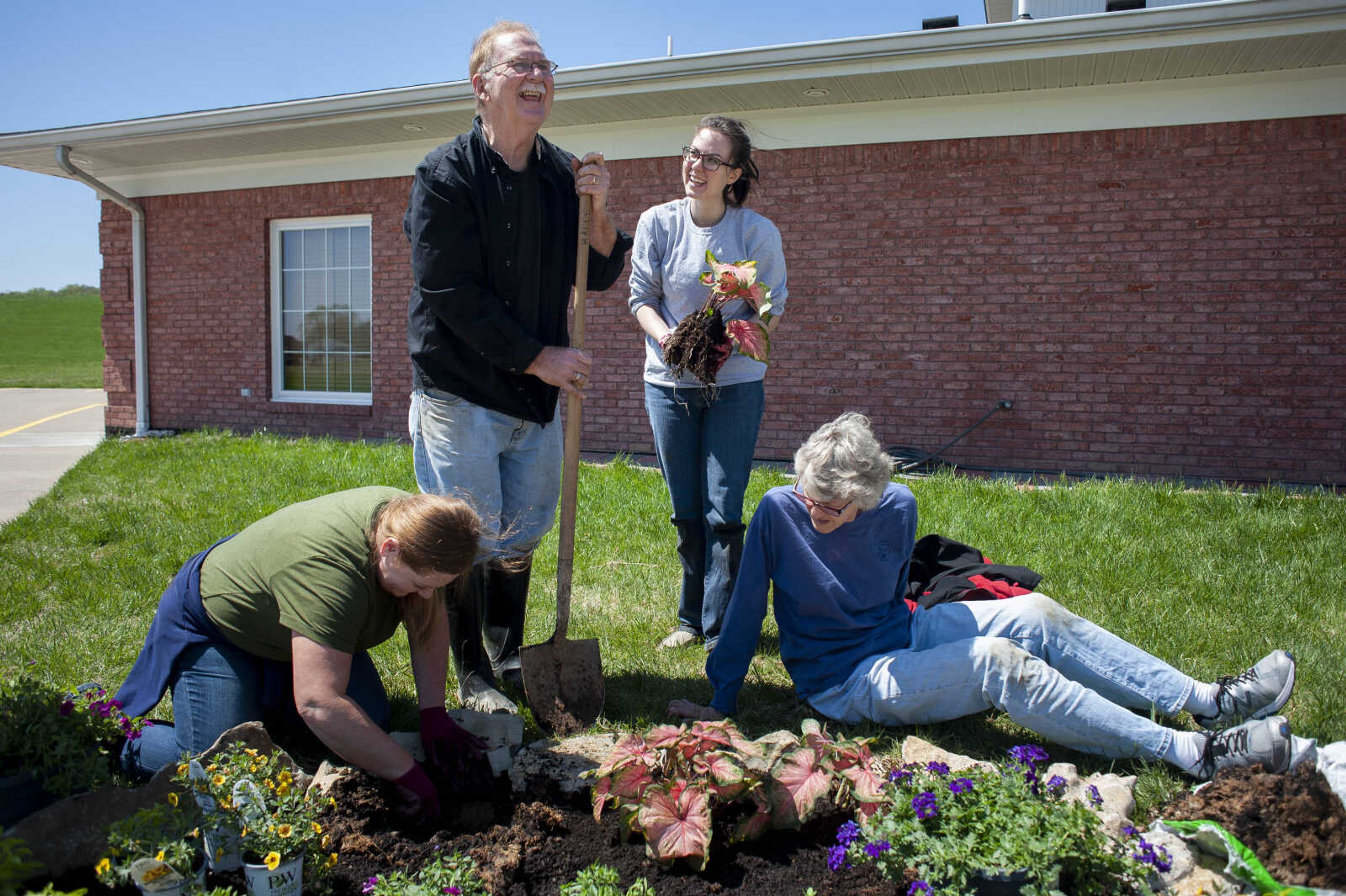 Randy Haley, with shovel, and Kristen Greer, standing, laugh while planting a flower bed with Wendy Farrow, bottom left, and Haley's wife Claudia Haley, all of Cape Girardeau, on Monday, April 15, 2019, at Kingdom Hall of Jehovah's Witnesses in Cape Girardeau. "Maybe one or two years ago or something we had to do some remodeling for issues with drainage," Greer said. "We had laid some sod and then now we're just getting around to planting some flowers."