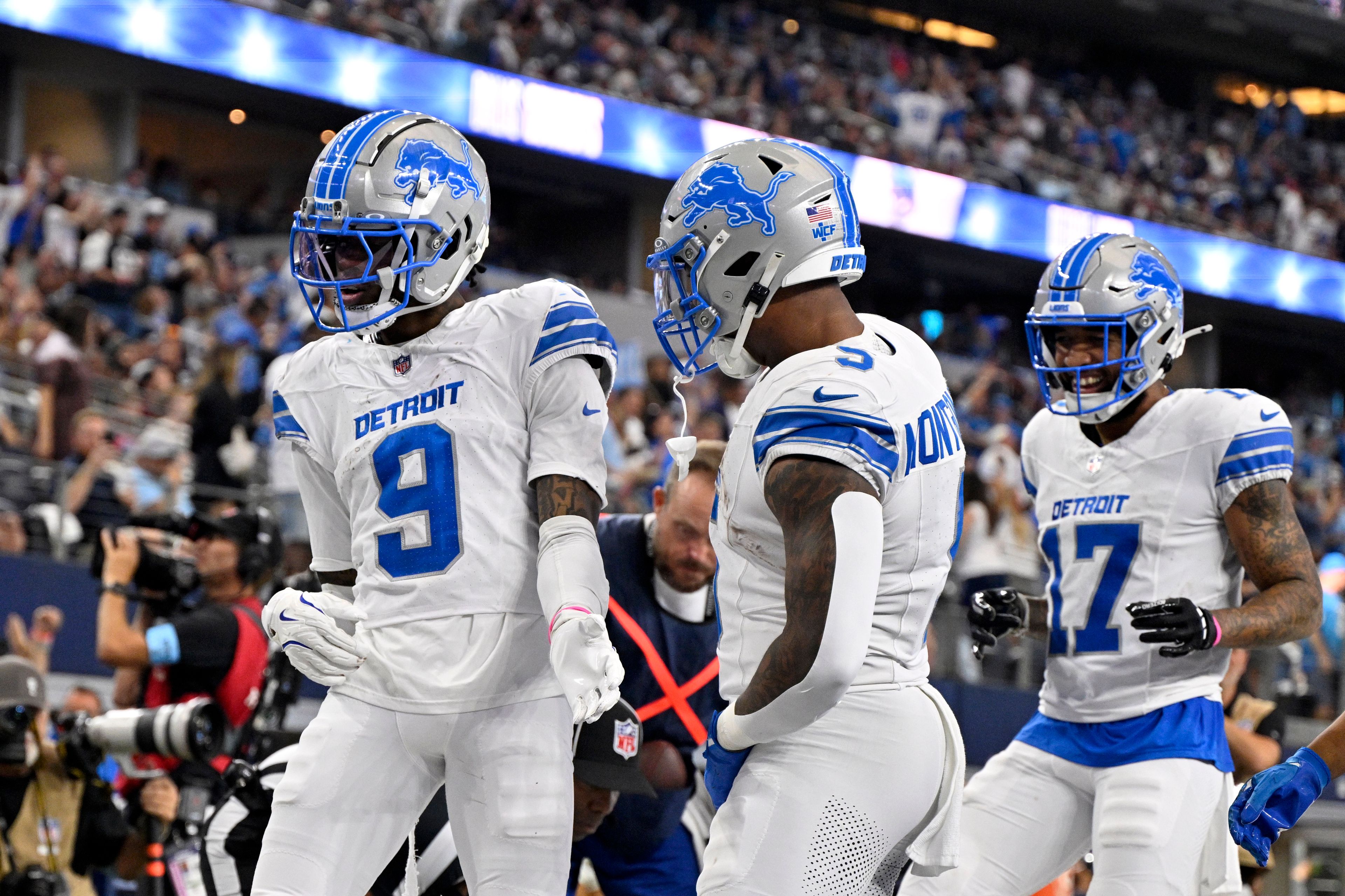 Detroit Lions' Jameson Williams (9), David Montgomery (5) and Tim Patrick (17) celebrate after Williams caught a touchdown pass in the second half of an NFL football game against the Dallas Cowboys in Arlington, Texas, Sunday, Oct. 13, 2024. (AP Photo/Jerome Miron)