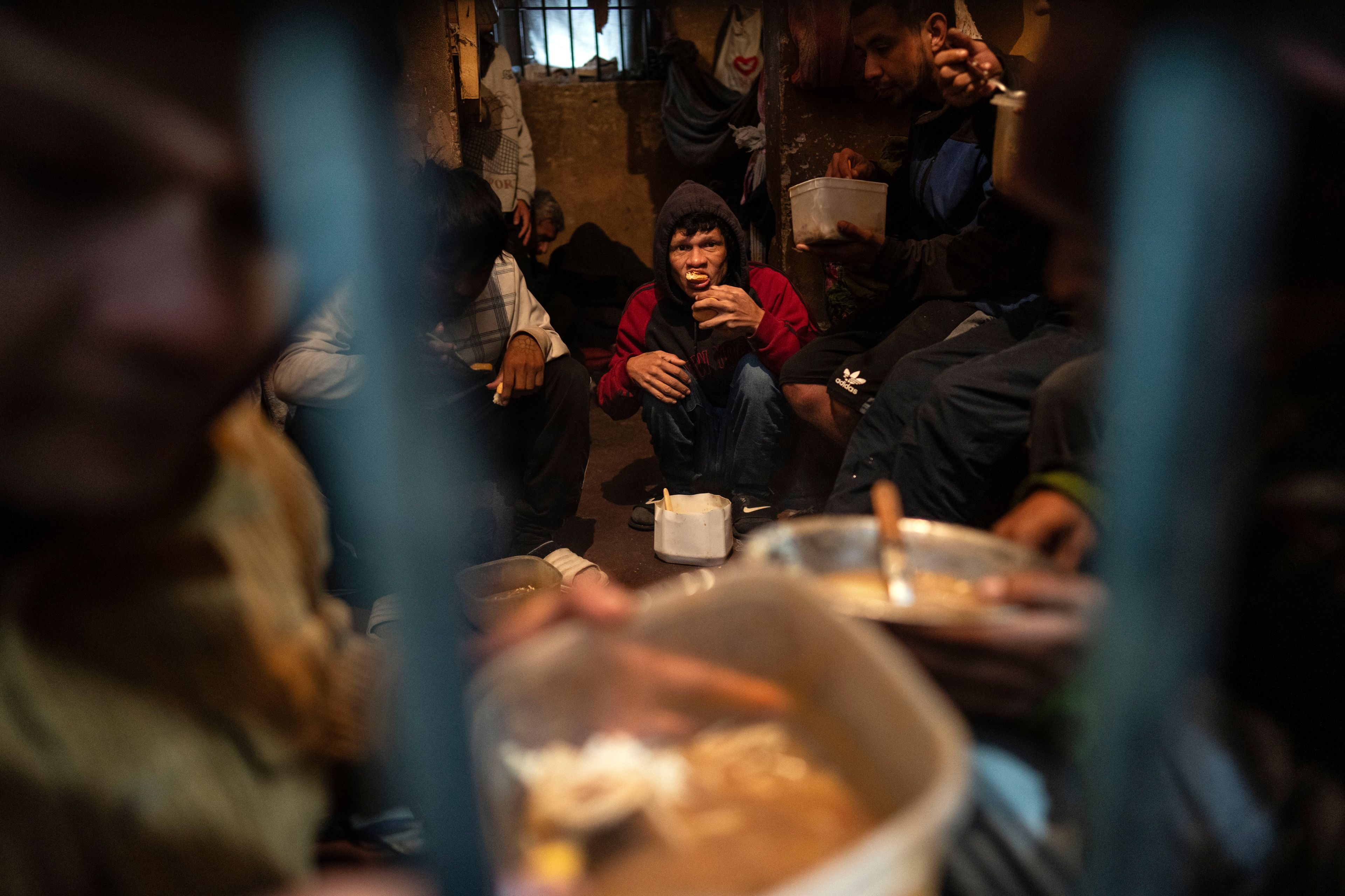 Prisoners eat dinner in their cell at the Juan de la Vega prison in Emboscada, Paraguay, Friday, July 12, 2024. (AP Photo/Rodrigo Abd)