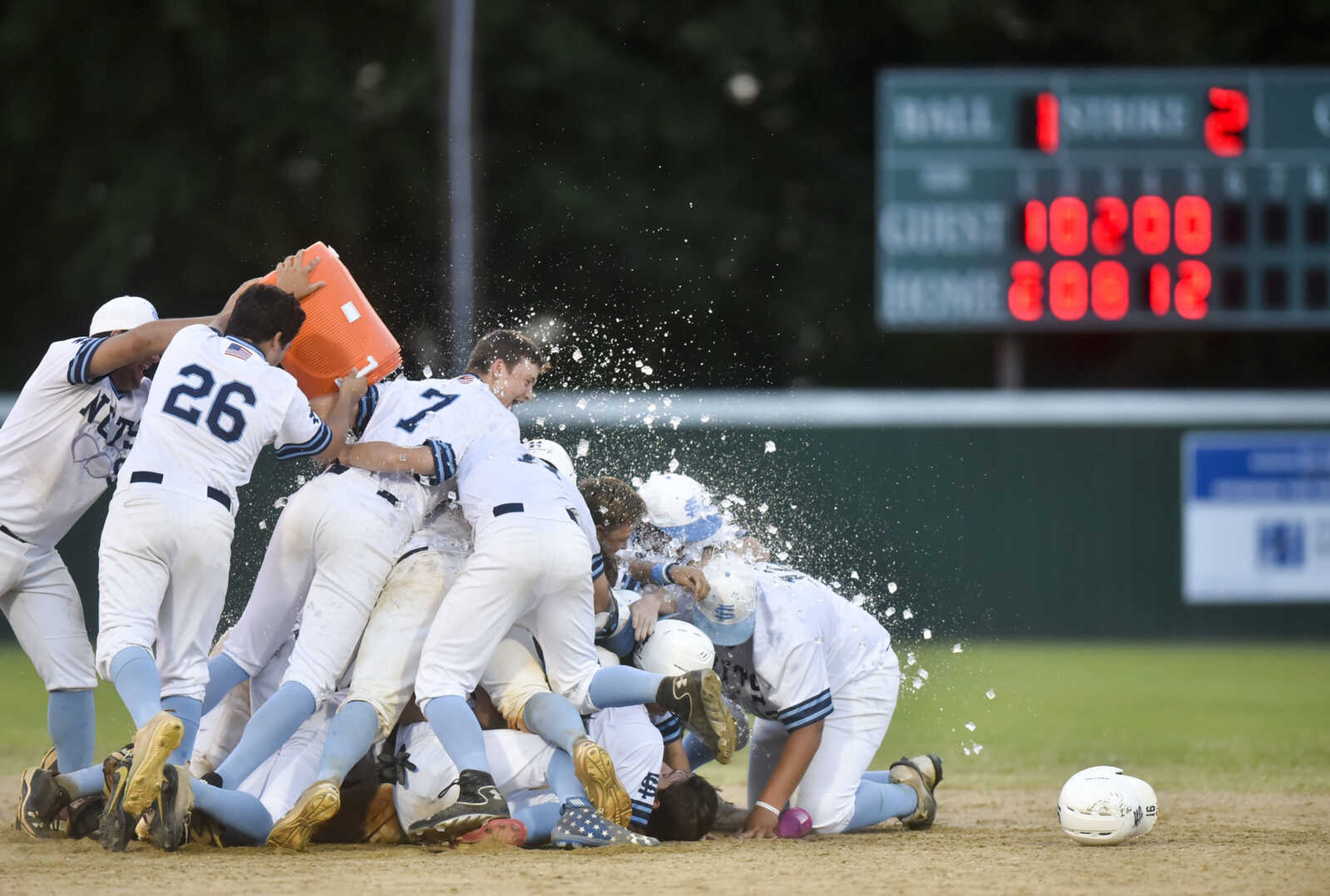 Charleston's Dallan Stotts is tackled at second base by his teammates after driving in a run to defeat Ultimate Sports by the 10-run rule on Sunday, July 8, 2018, at Benny Hillhouse Park in Charleston, Missouri.