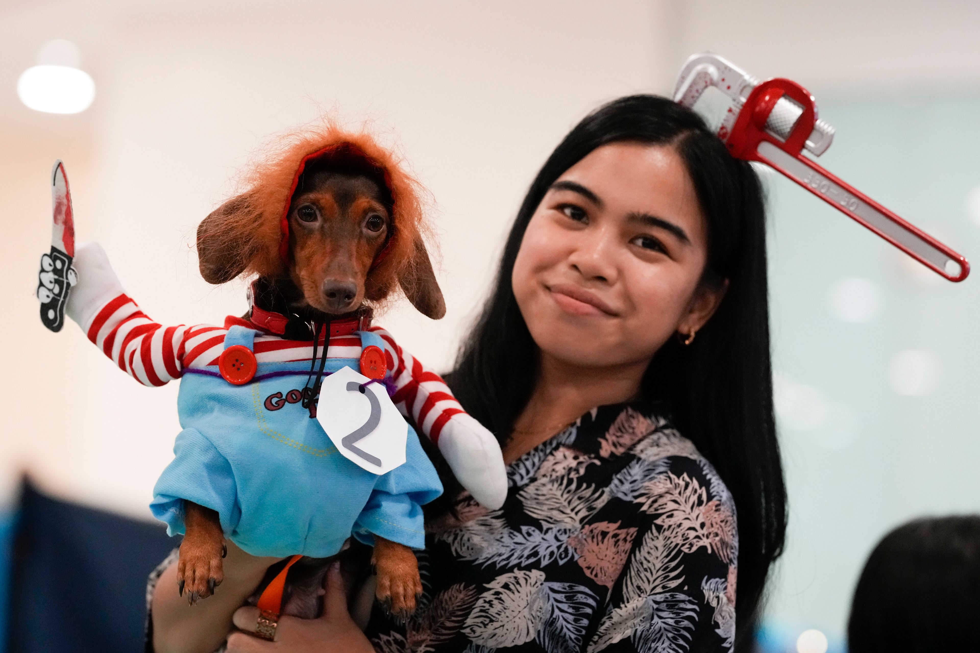 Karyll Cabutotan, right, poses with her dog Truffle during a Halloween pet party at a mall in Valenzuela city, Philippines on Saturday, Oct. 19, 2024. (AP Photo/Aaron Favila)