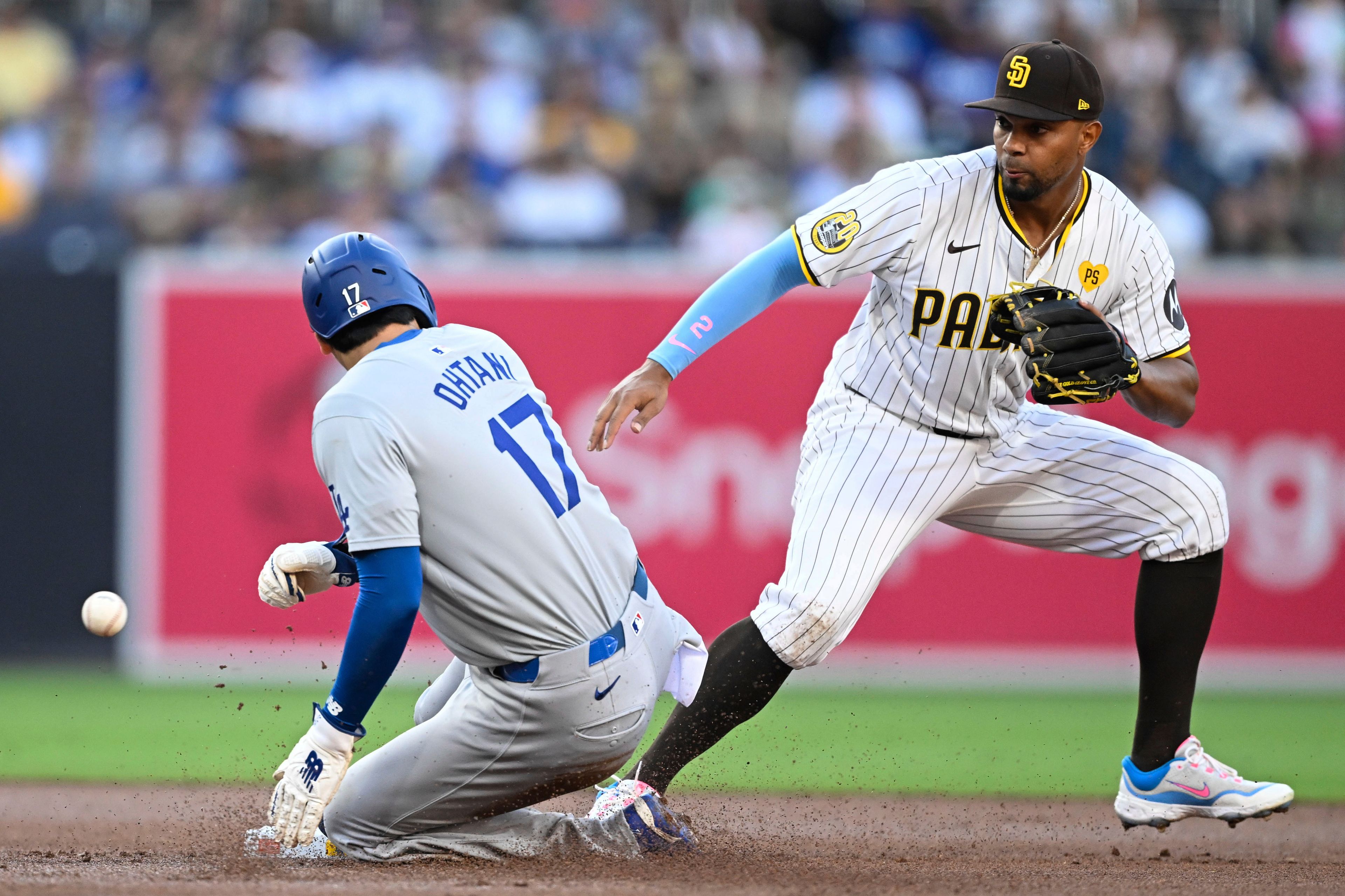 Los Angeles Dodgers designated hitter Shohei Ohtani (17) steals second base ahead of the throw to San Diego Padres second baseman Xander Bogaerts (2) during the first inning of a baseball game Tuesday, July 30, 2024, in San Diego. (AP Photo/Denis Poroy)