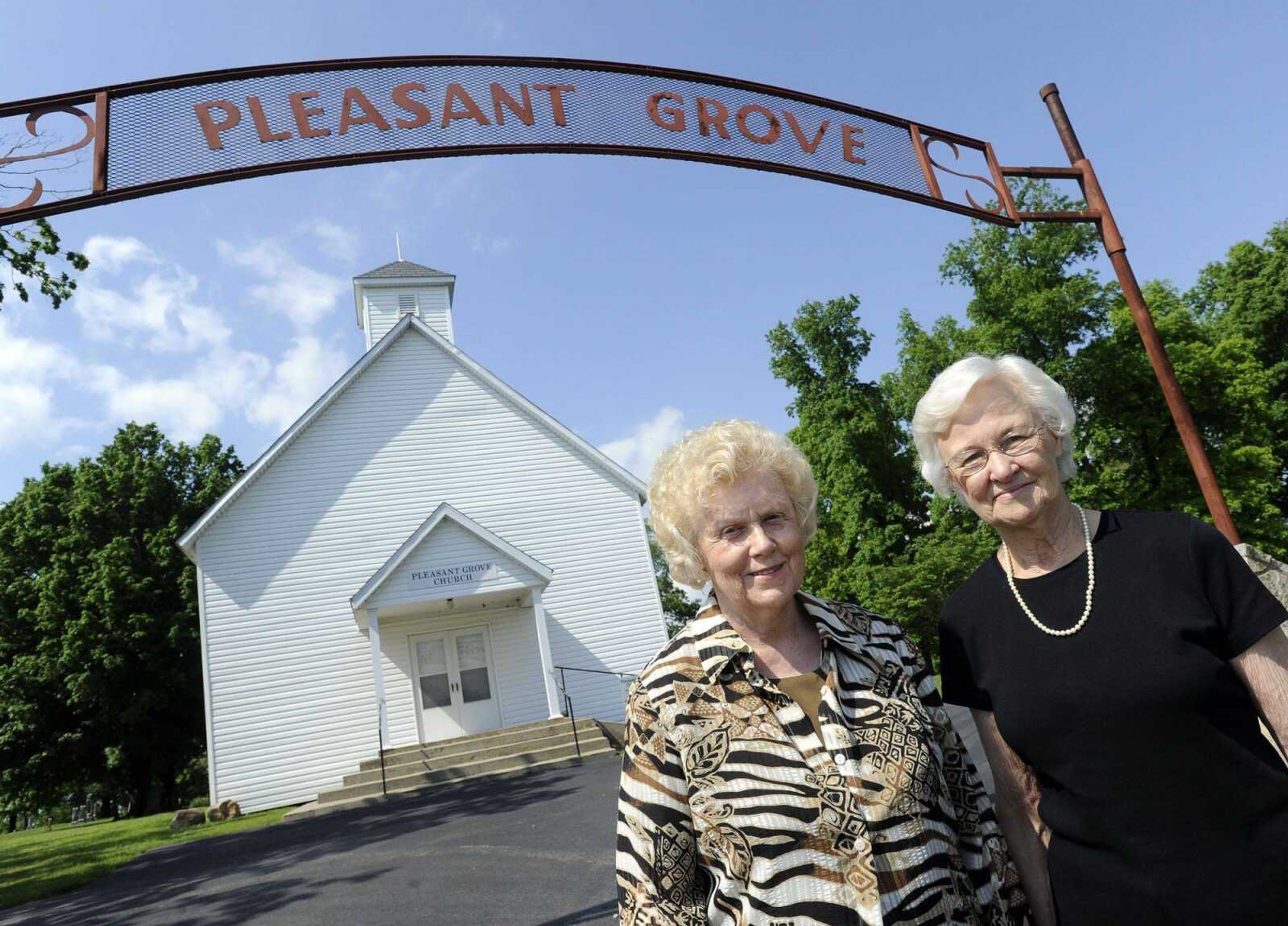 Michal Sue Prosser-Burlison, left, president of the Pleasant Grove Cemetery Association, and secretary-treasurer Shelby Mann-Spears, stand outside the Pleasant Grove Church. The group will mark the 125th anniversary of the church on May 26 with a memorial service and business meeting. (Fred Lynch)