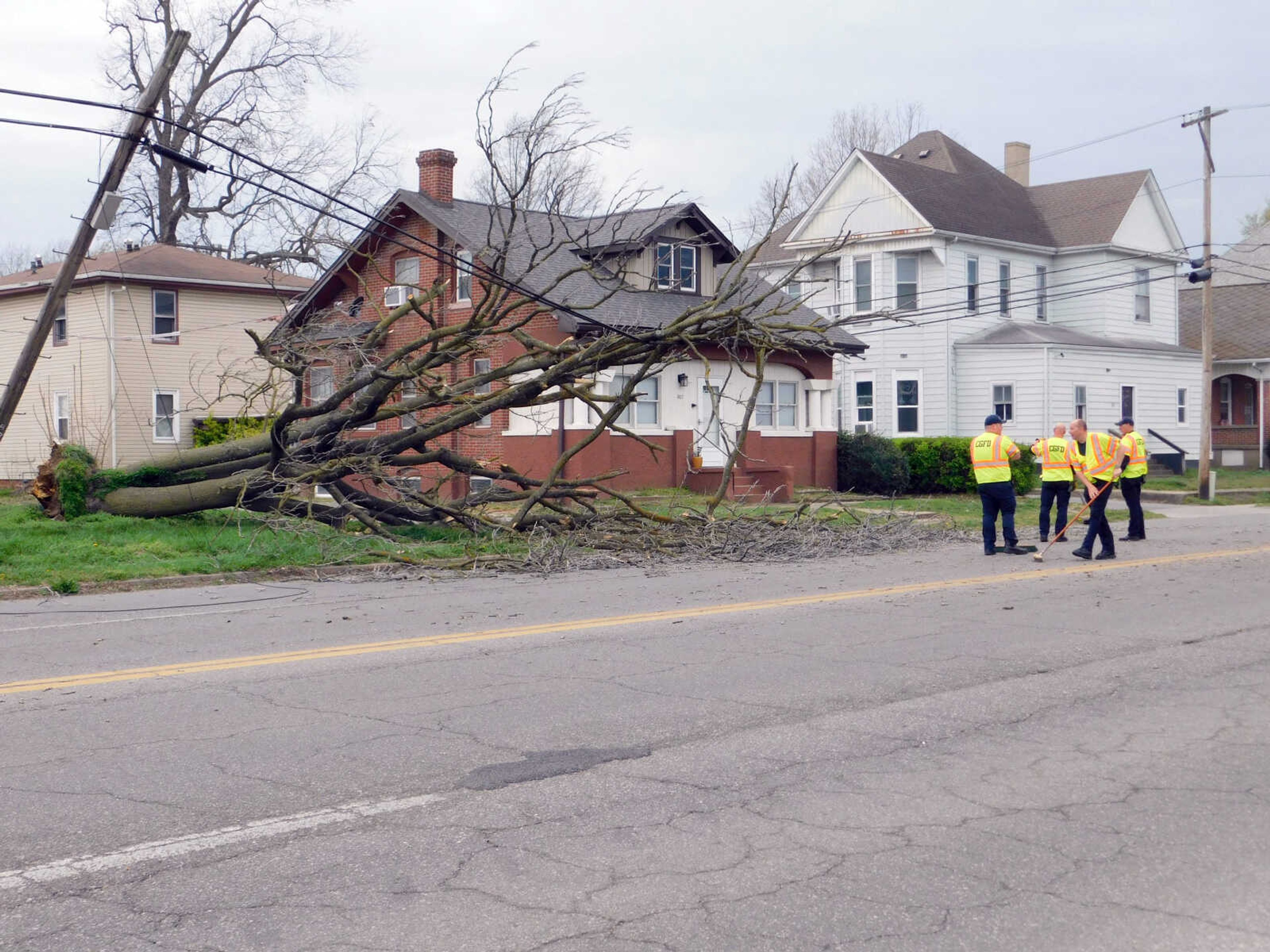 Cape Girardeau Fire Department firefighters remove fallen branches from William Street on Monday, March 25. Just after 5 p.m., high winds tore down an old tree. The tree fell onto power lines, breaking a telephone pole and forcing emergency services to block off access near the intersection of William Street and South Ellis Street.