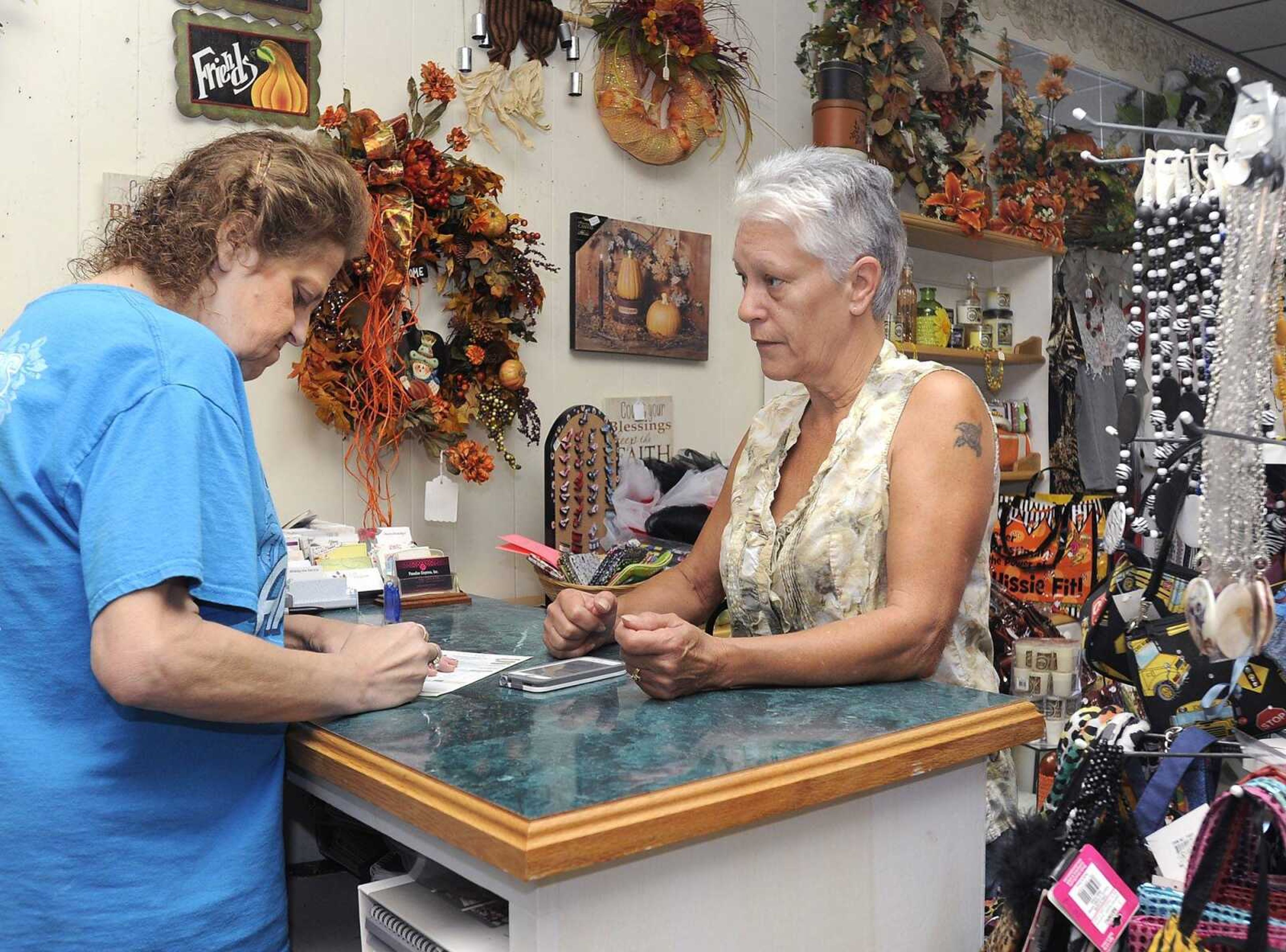 Mary Kinder, right, orders flowers with Dawn Razer, a clerk at Paradise Express on Saturday in Scott City. The business is one of a few in the old Illmo section of town. (Fred Lynch)