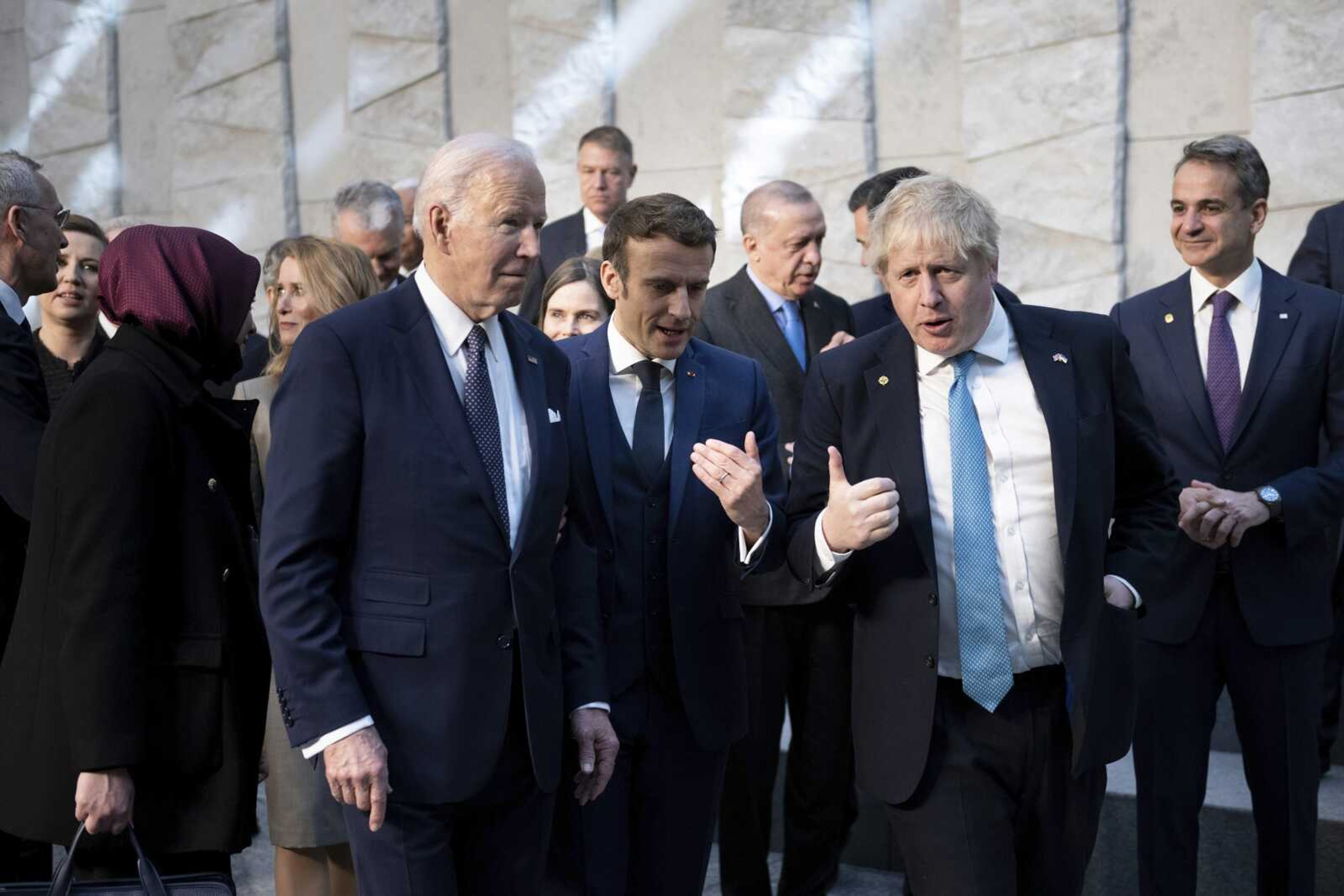 President Joe Biden, left, talks with French President Emmanuel Macron and British Prime Minister Boris Johnson, right, as they arrive at NATO Headquarters on Thursday in Brussels.