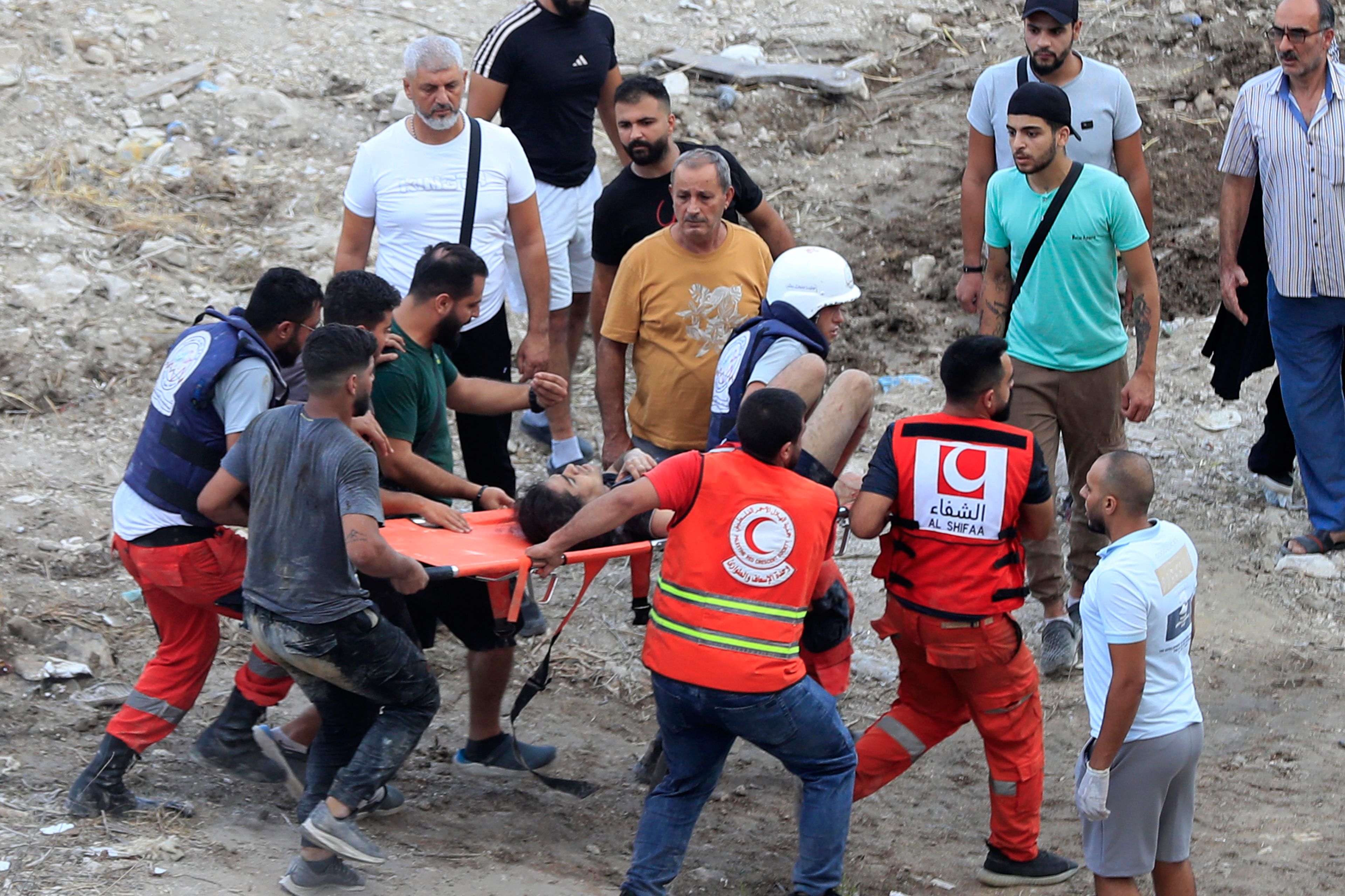 Rescue workers carry a man who was injured after an Israeli airstrike hit two adjacent buildings, in Ain el-Delb neighbourhood east of the southern port city of Sidon, Lebanon, Sunday, Sept. 29, 2024. (AP Photo/Mohammed Zaatari)