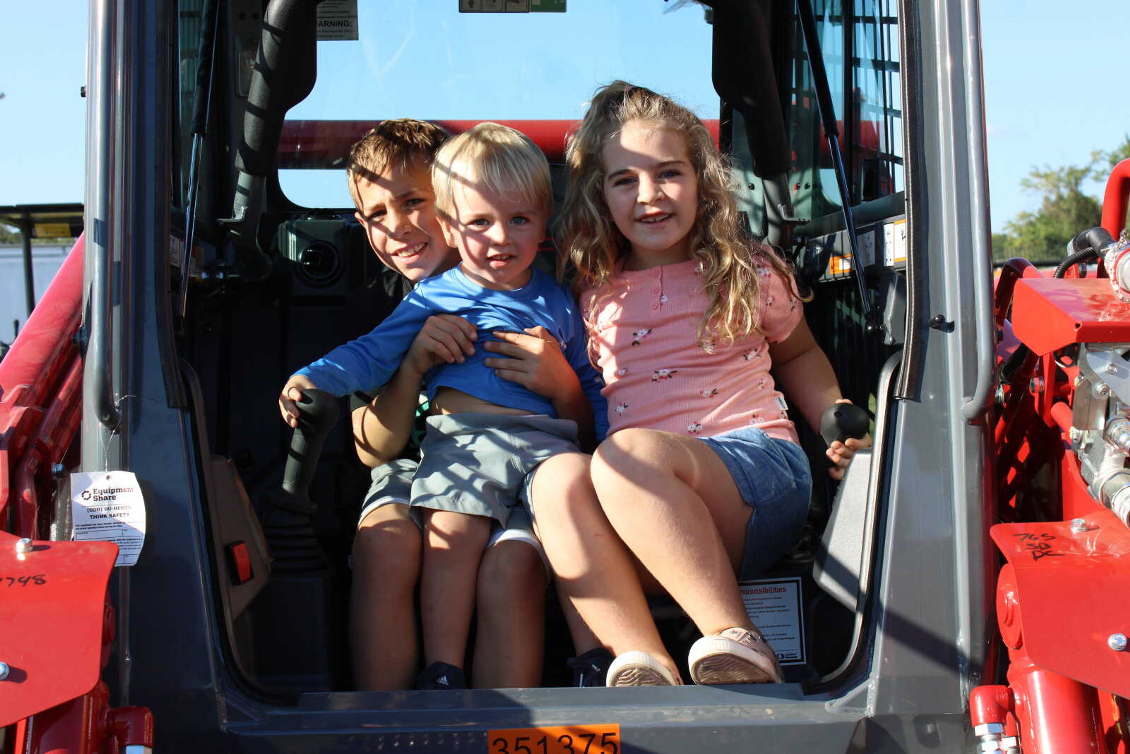 Siblings, Jameson Rehan, Weston Rehan and Mclaine Rehan squish into a tractor seat.&nbsp;