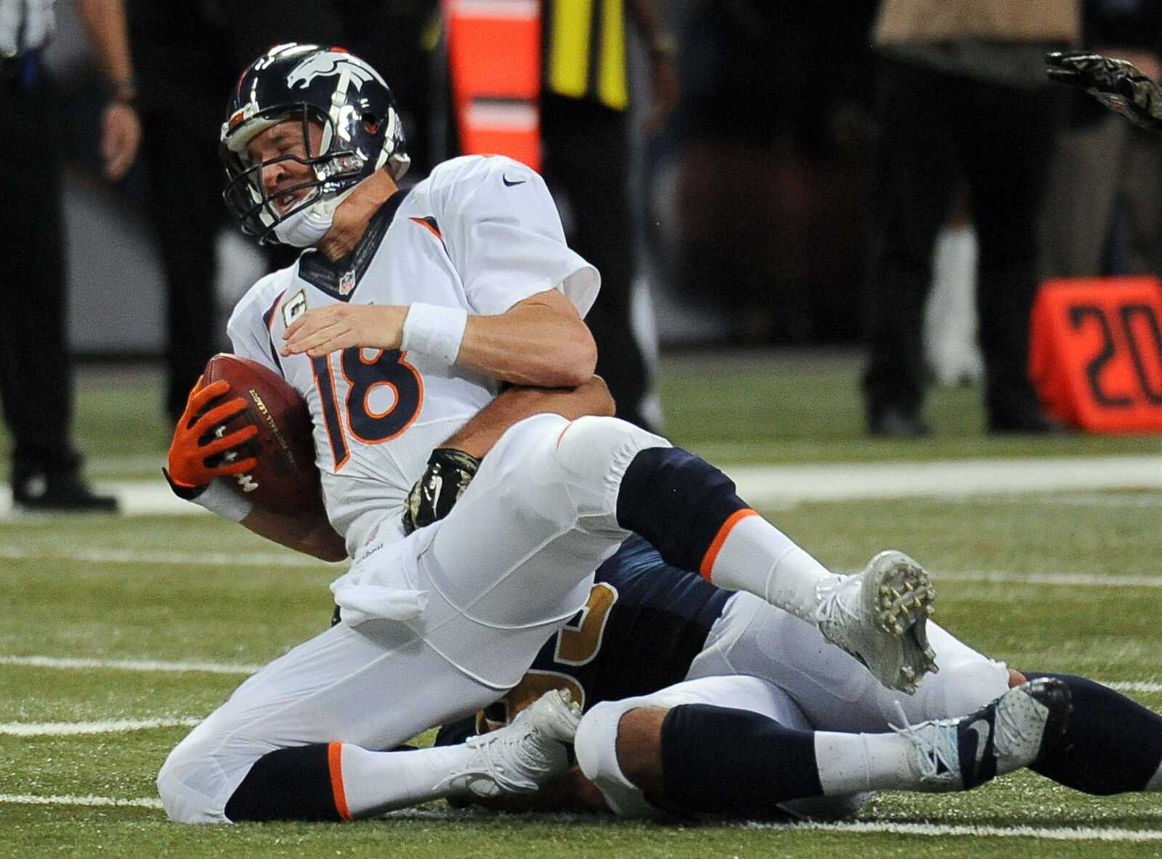 Broncos quarterback Peyton Manning, left, is sacked for a 12-yard loss by Rams defensive tackle Aaron Donald during the fourth quarter Sunday in St. Louis. The Rams' Robert Quinn also received half credit for the sack. (L.G. Patterson ~ Associated Press)