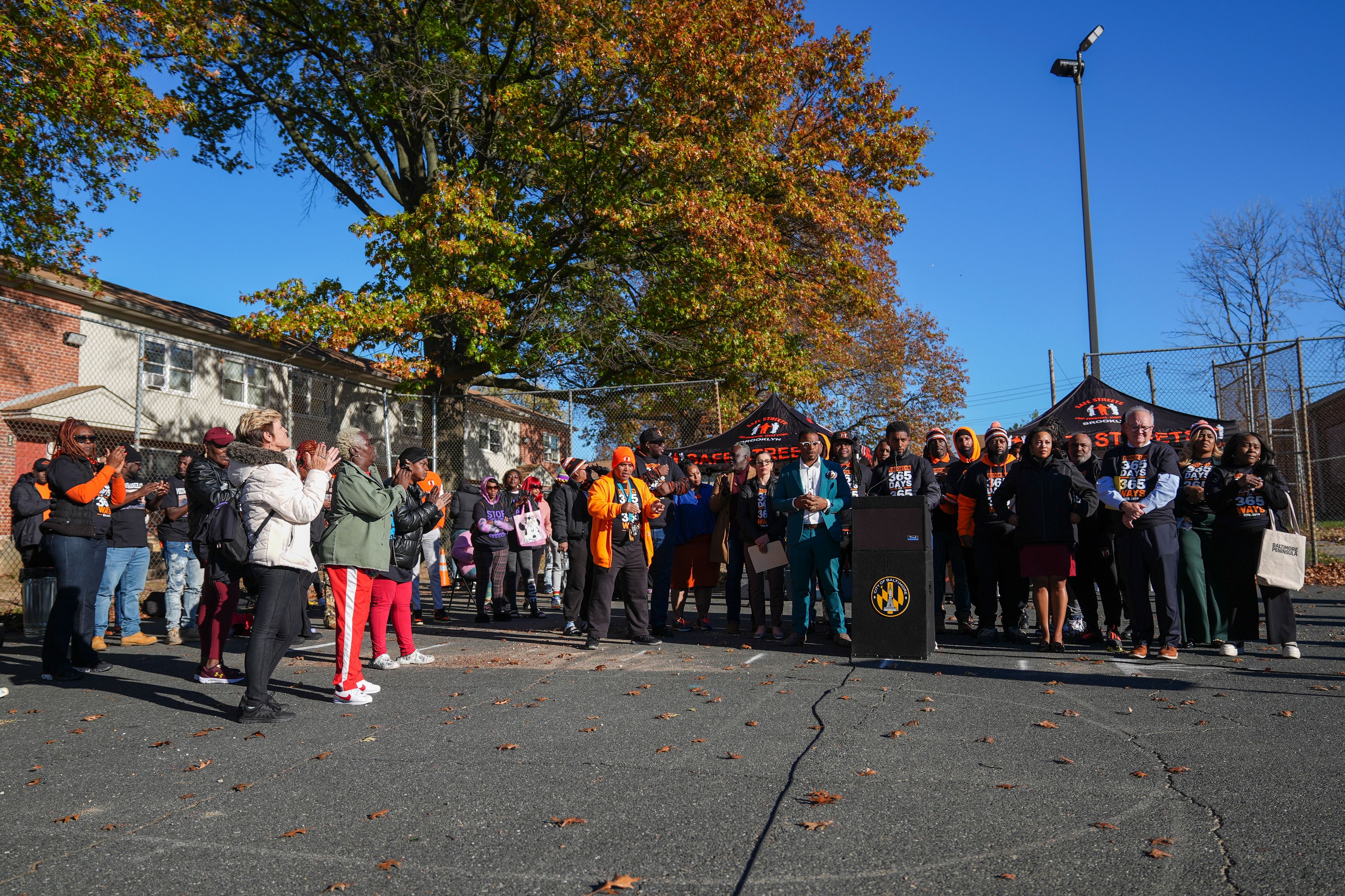 Community members applaud as Baltimore Mayor Brandon Scott speaks during a press conference to celebrate achieving over 365 days without a homicide within the Brooklyn neighborhood Safe Streets catchment zone, Tuesday, Nov. 12, 2024, in Baltimore. (AP Photo/Stephanie Scarbrough)